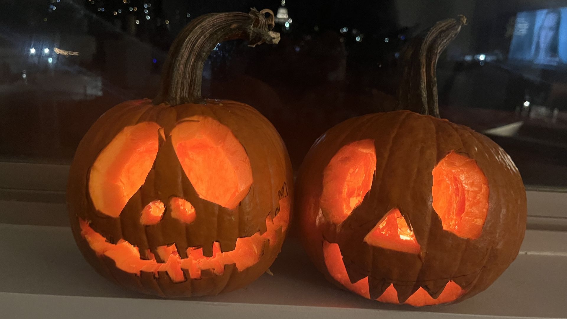 Two carved pumpkins in candlelight