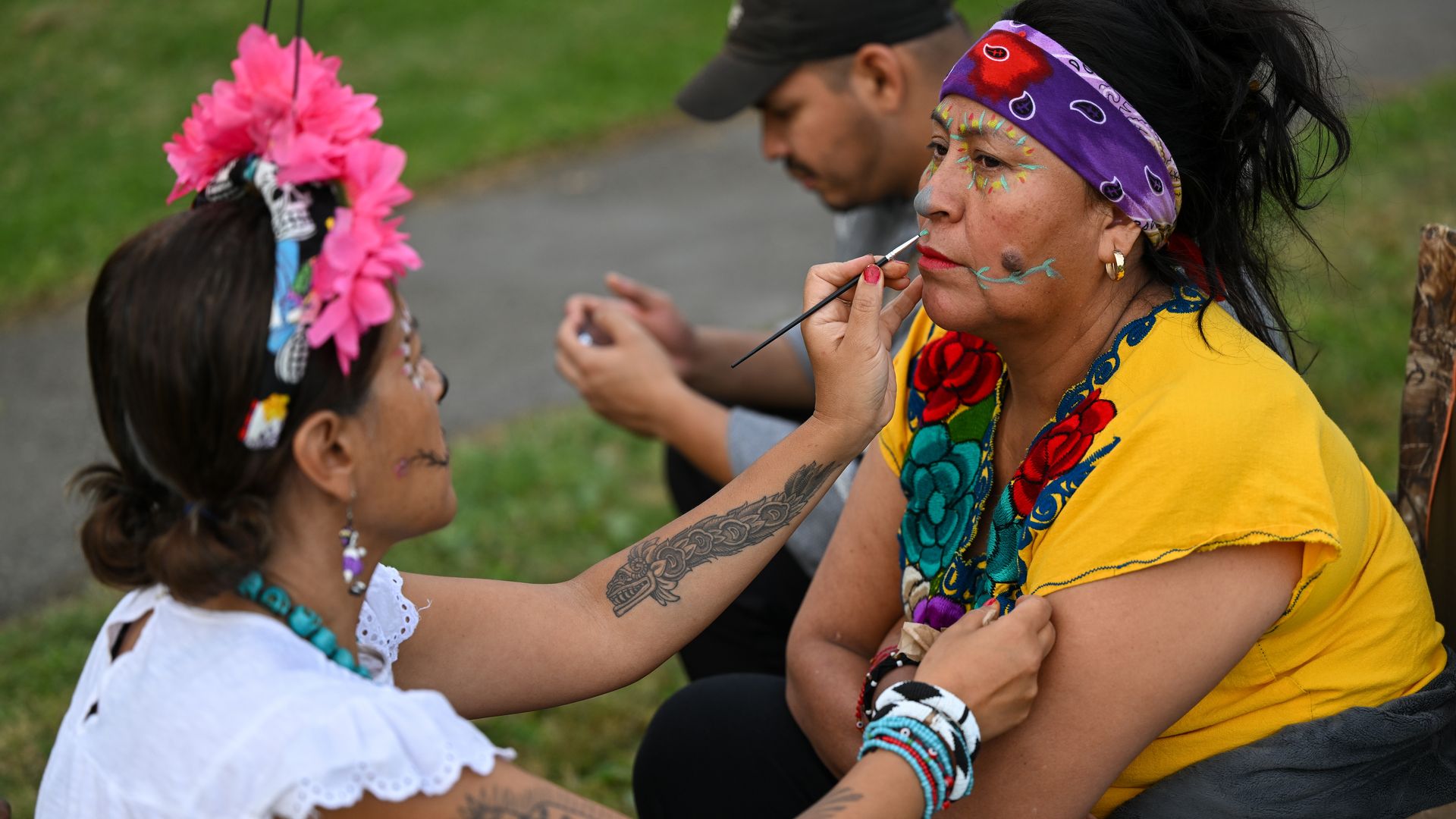 Photo of a person face painting another person