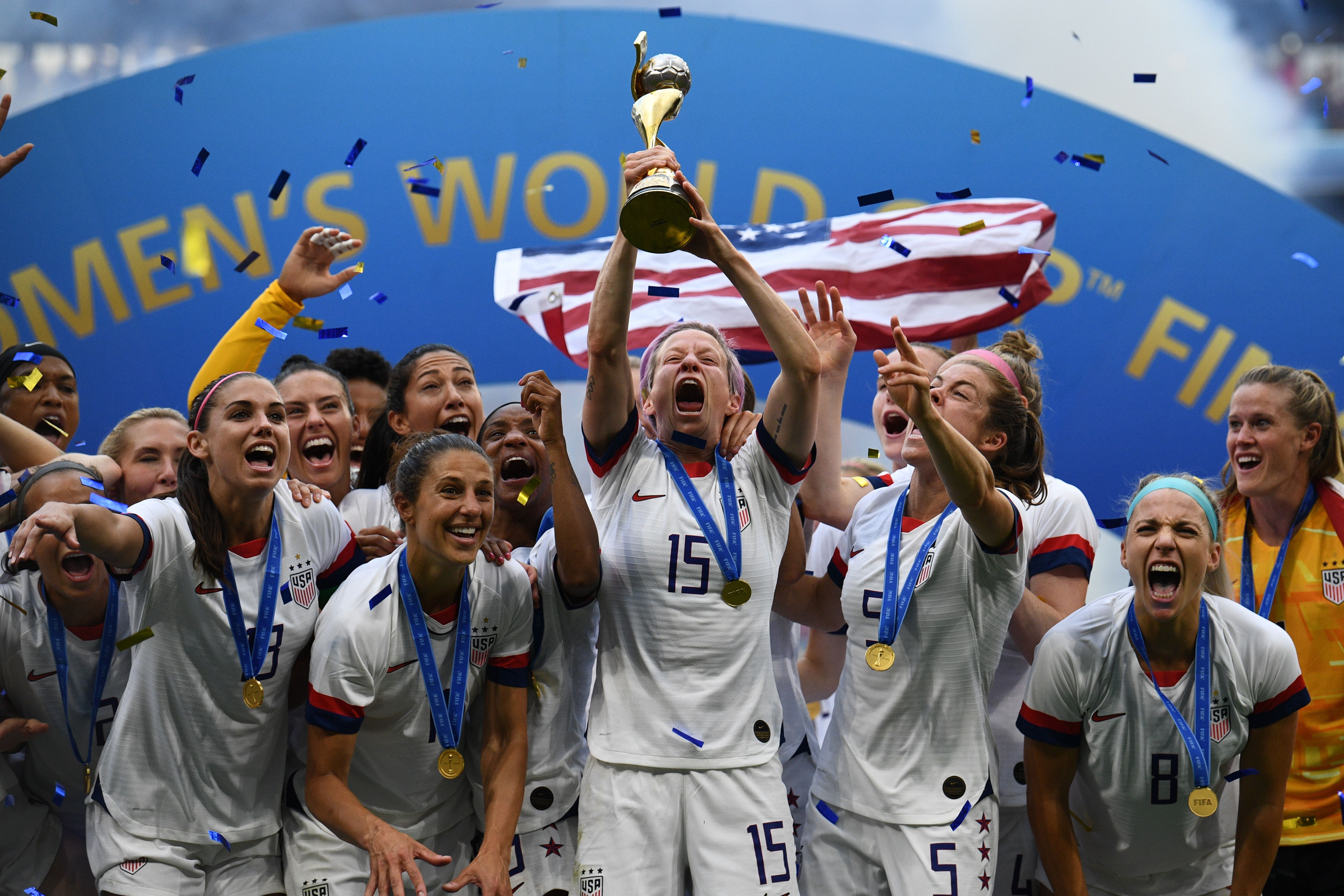  USA's players including forward Megan Rapinoe (C) celebrate with the trophy after the France 2019 Womens World Cup football final