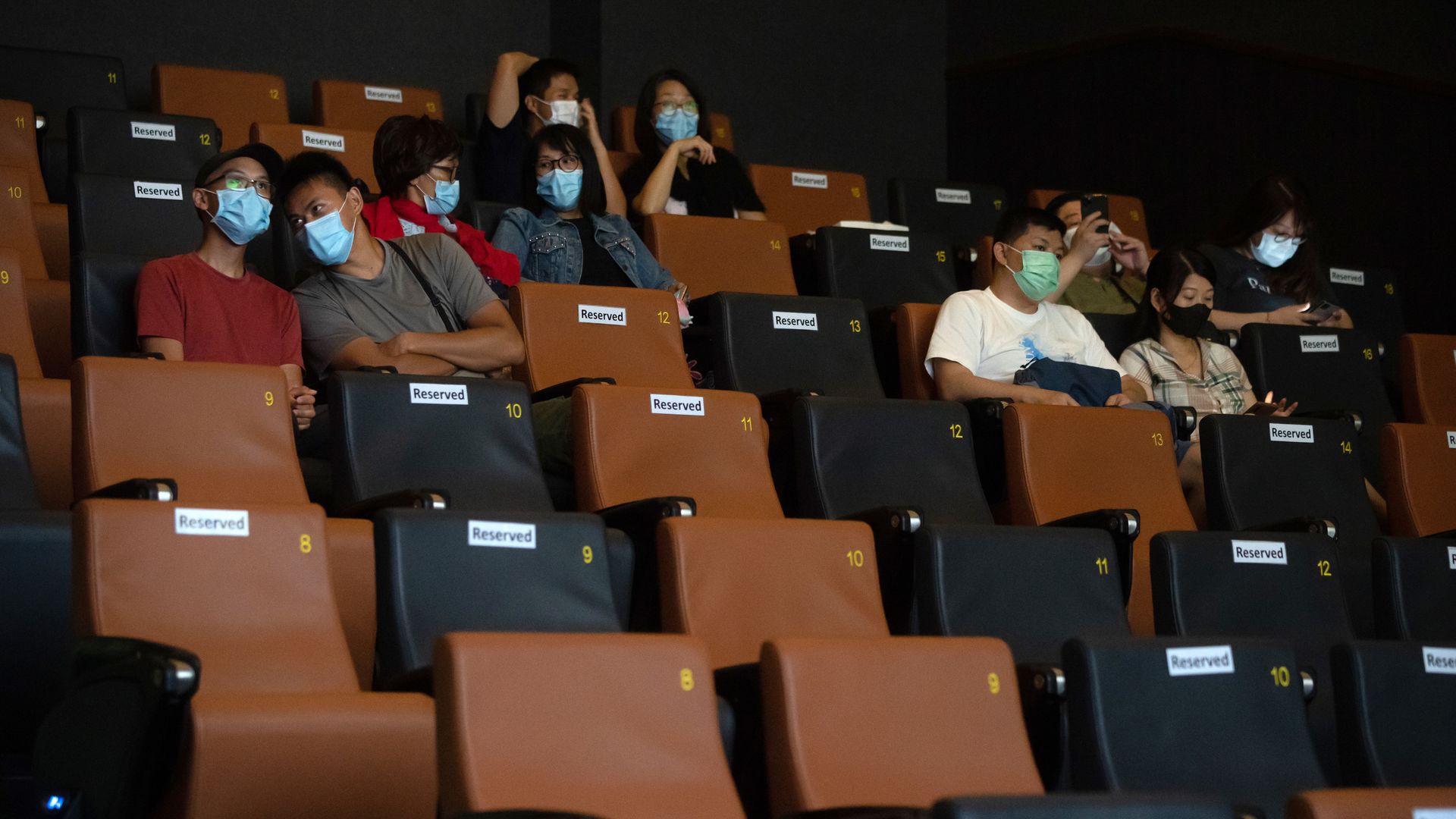Picture of the inside of a movie theater in Hong Kong with people sitting apart and respecting social distancing measures