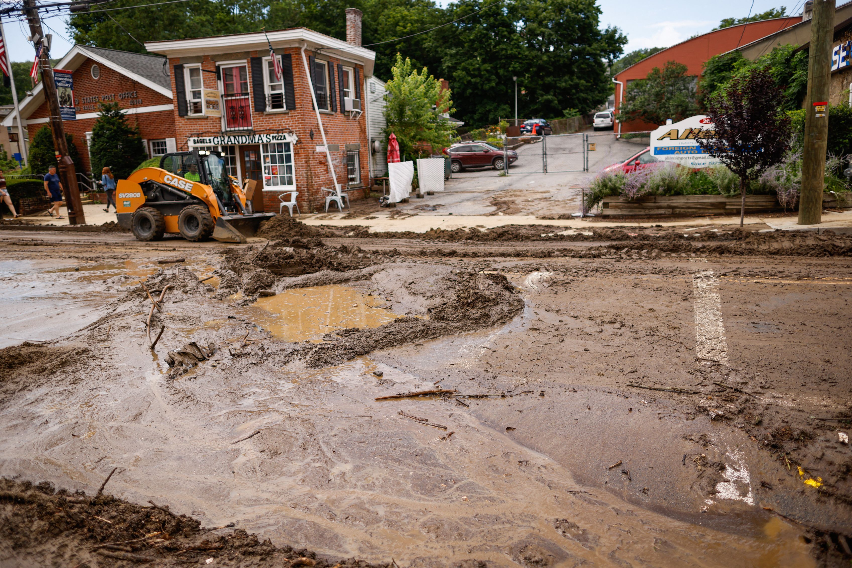 Workers remove mud from Main street after heavy rains in Highland Falls, New York, on July 10.