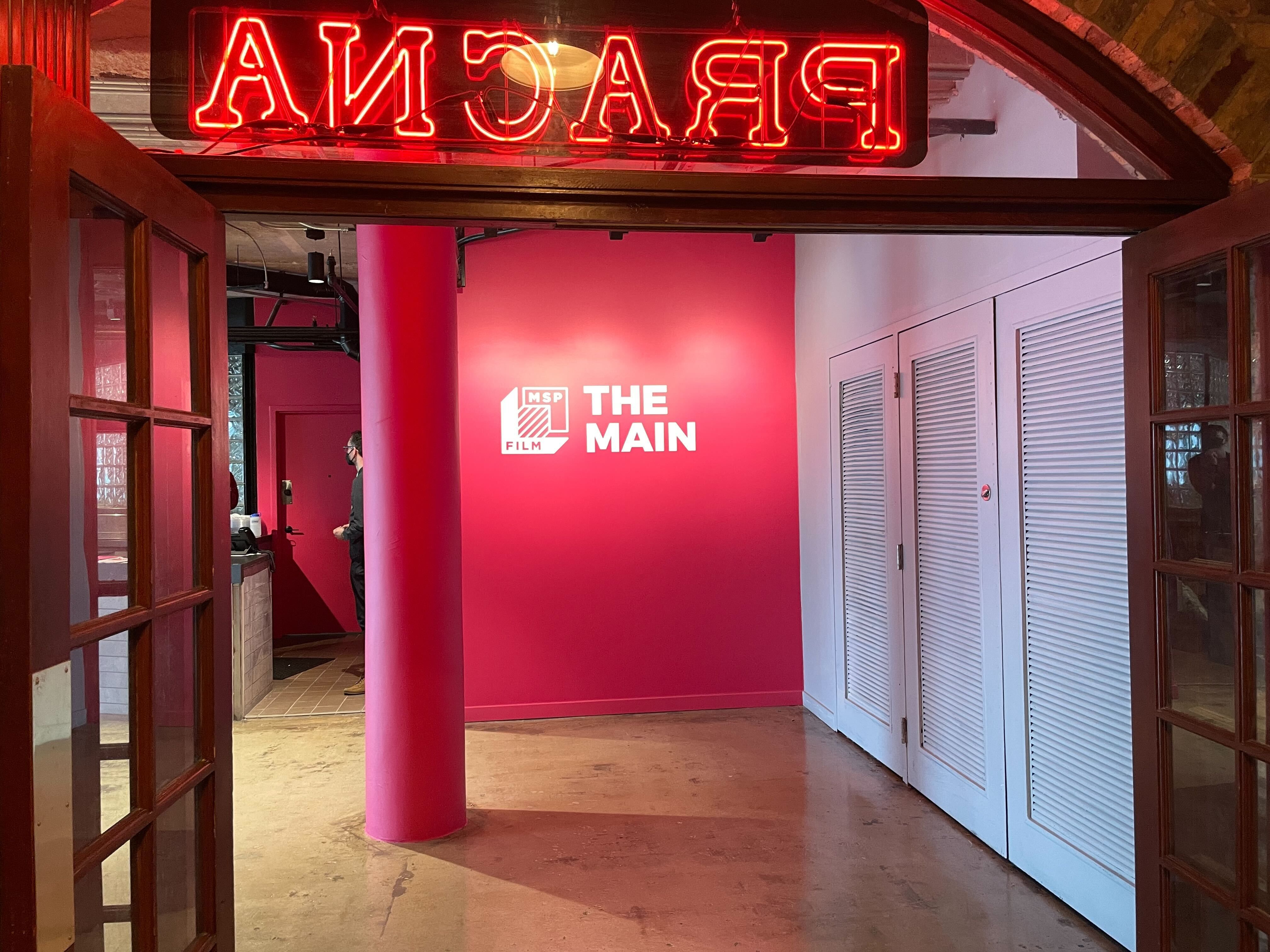 A bright pink wall that says The Main.