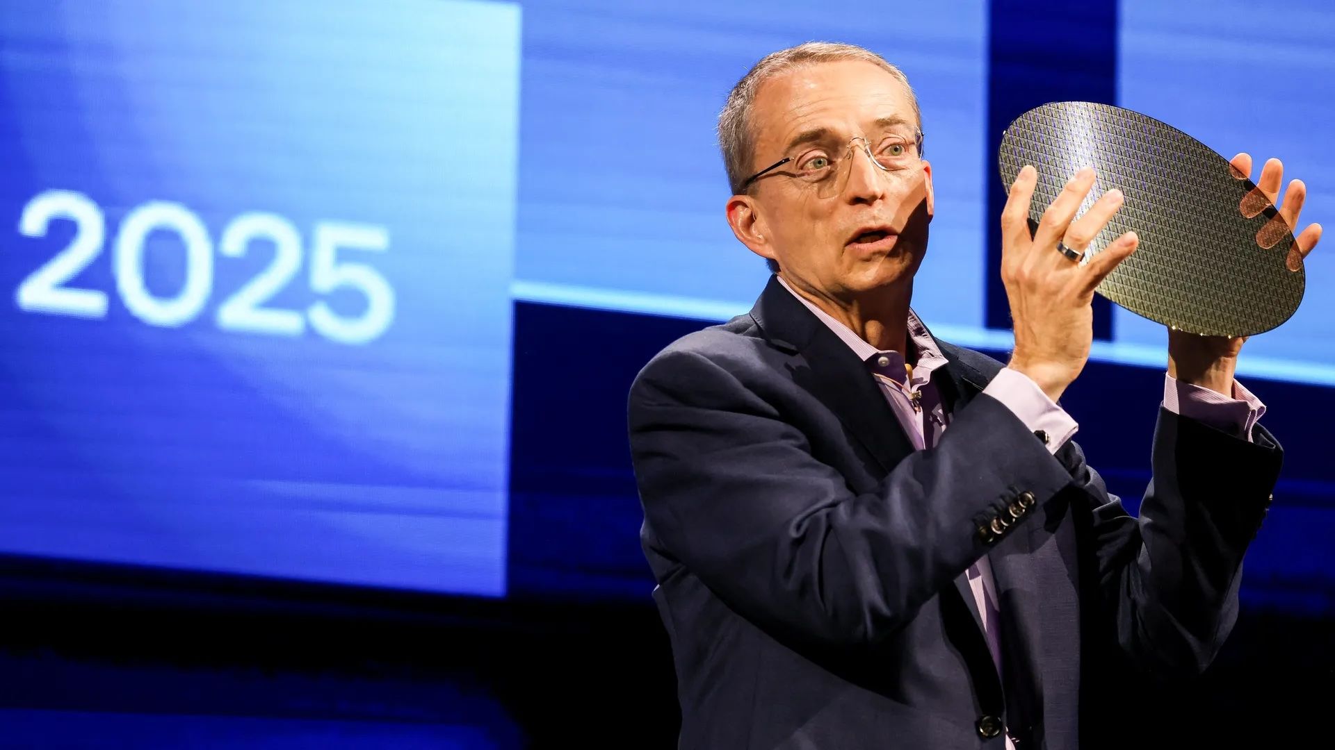 Intel's Pat Gelsinger holds up a round chip wafer
