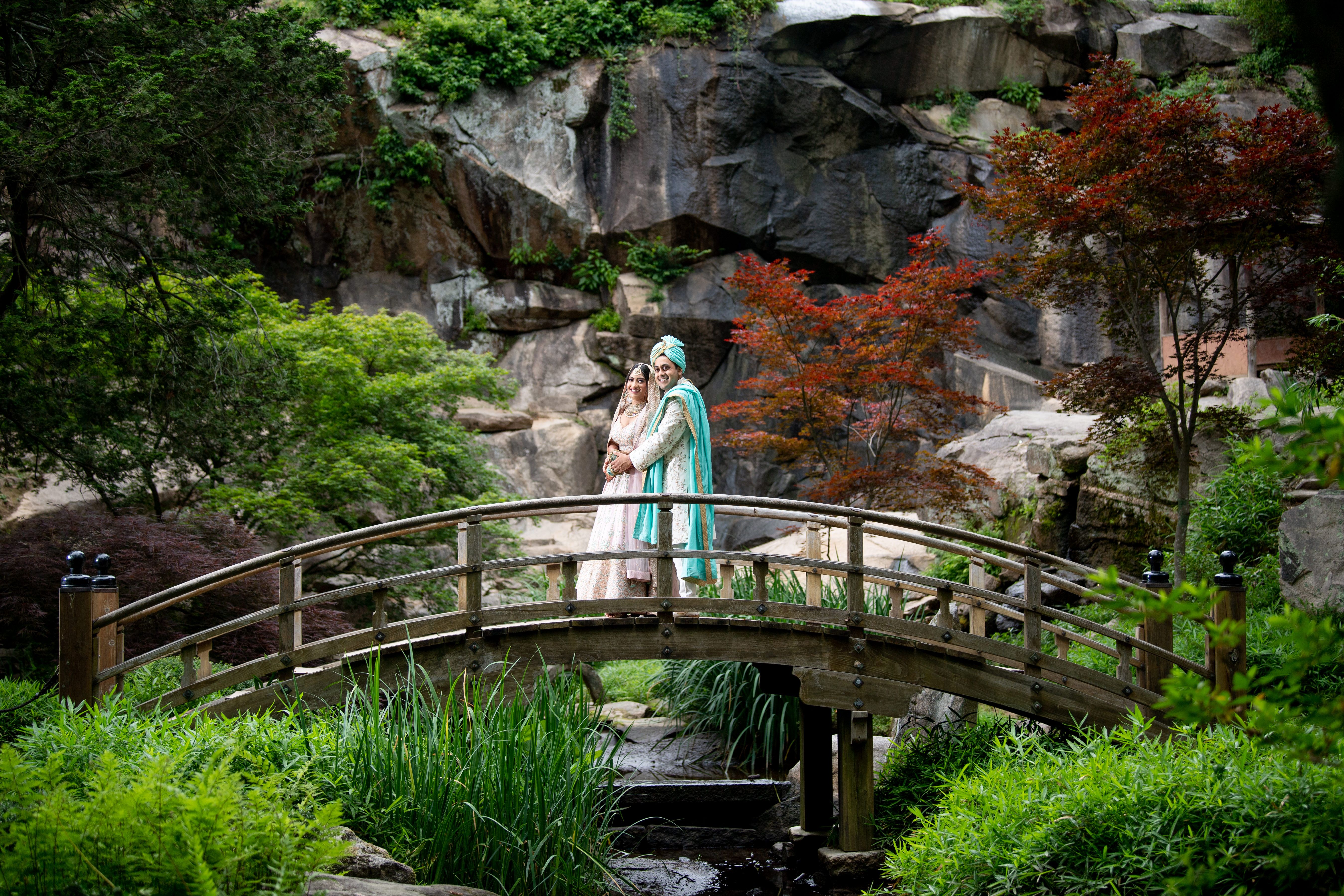 a coule standing on a bridge 