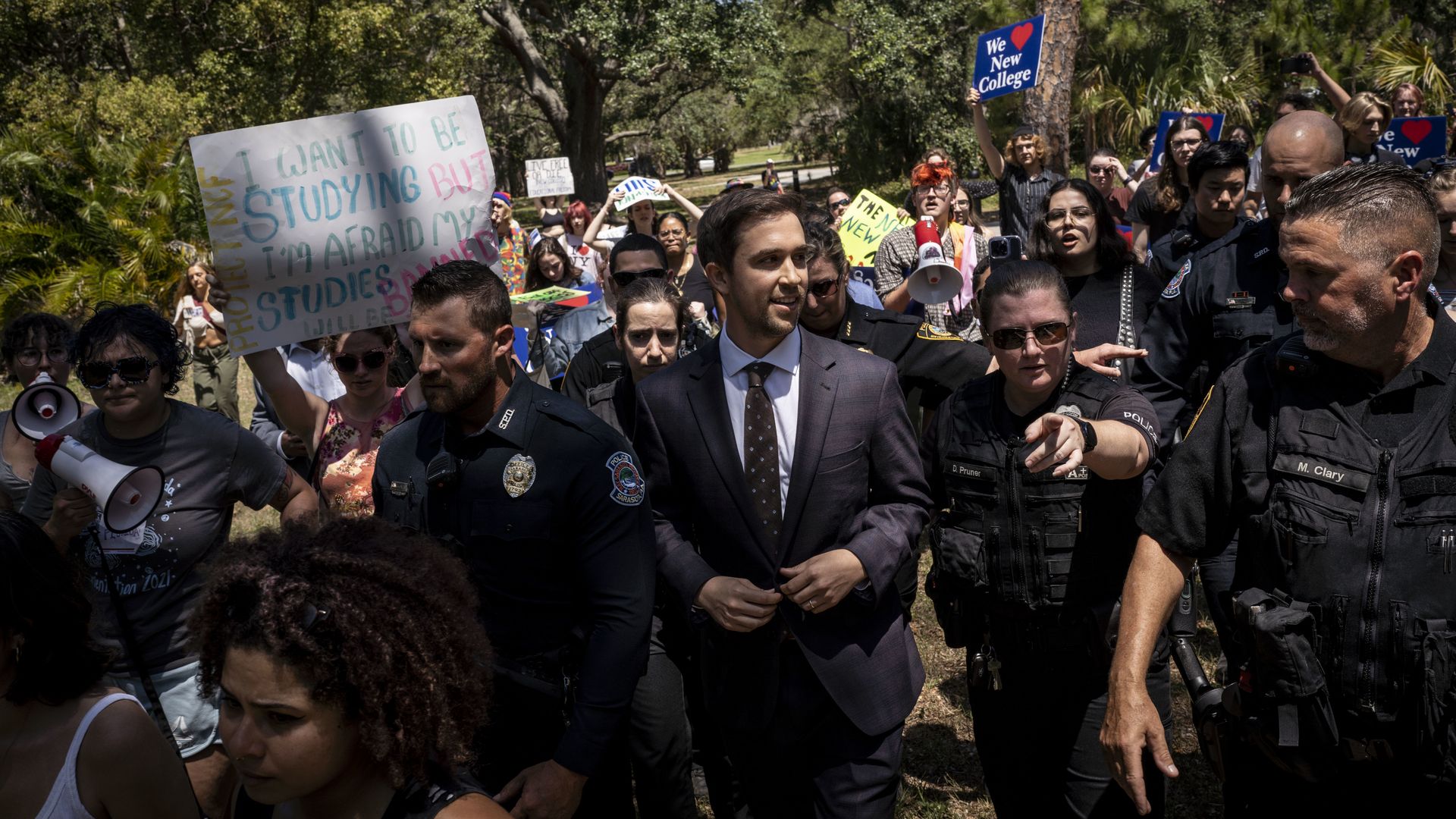 Christopher Rufo, a conservative activist and New College of Florida trustee, walks through protestors at the campus.