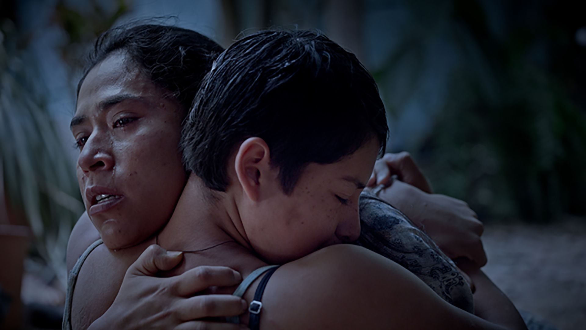 A daughter hugs her mother in a scene from the film "Prayers for the Stolen" (Noche de Fuego.