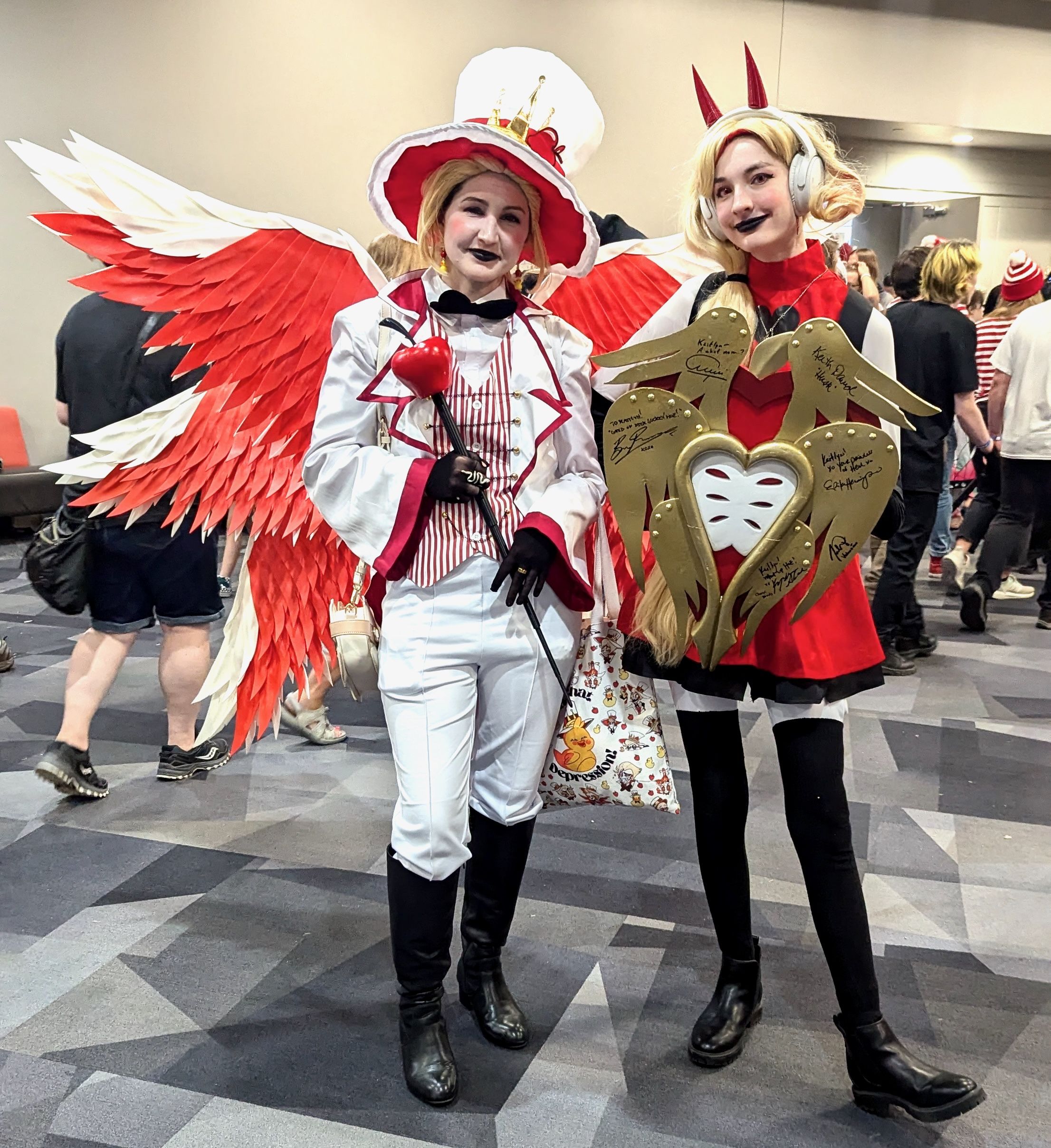 Two women costumed like characters from Hazbin Hotel.