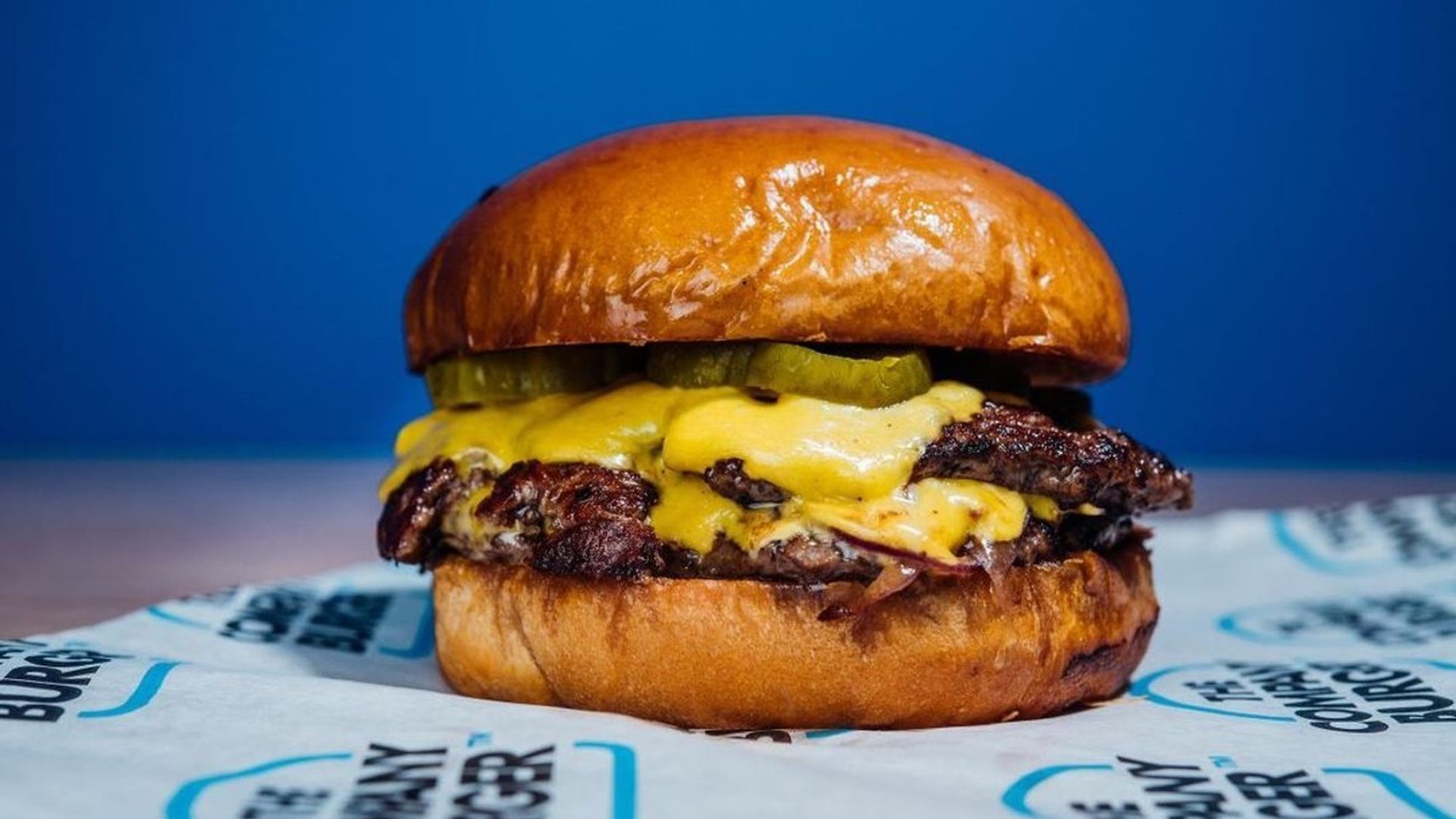 Photo shows a delicious-looking cheeseburger with two patties and pickles from Company Burger.