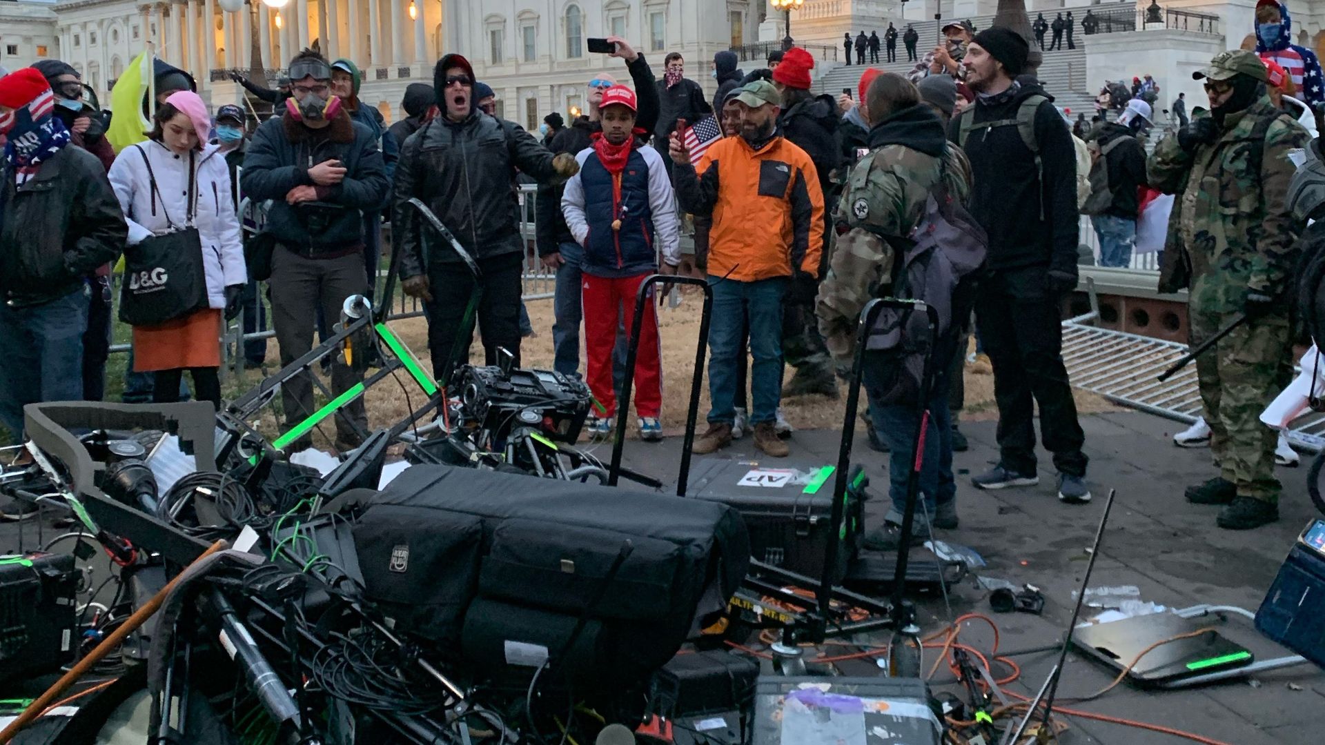 People stand around media equipment destroyed by Trump supporters outside the US Capitol in Washington DC on January 6