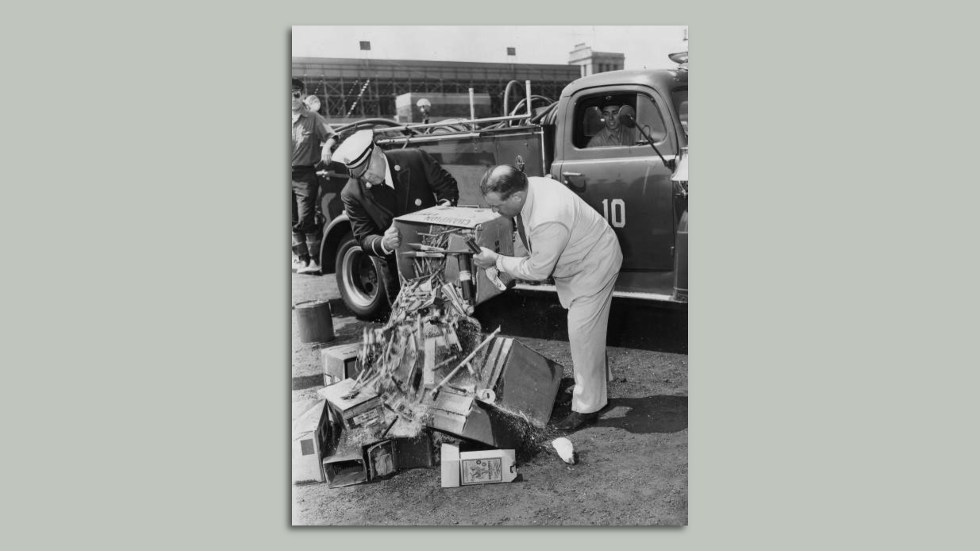 An archival photograph of Philadelphia fire officials dumping illegal Fourth of July fireworks seized by police at Municipal Stadium in 1953.