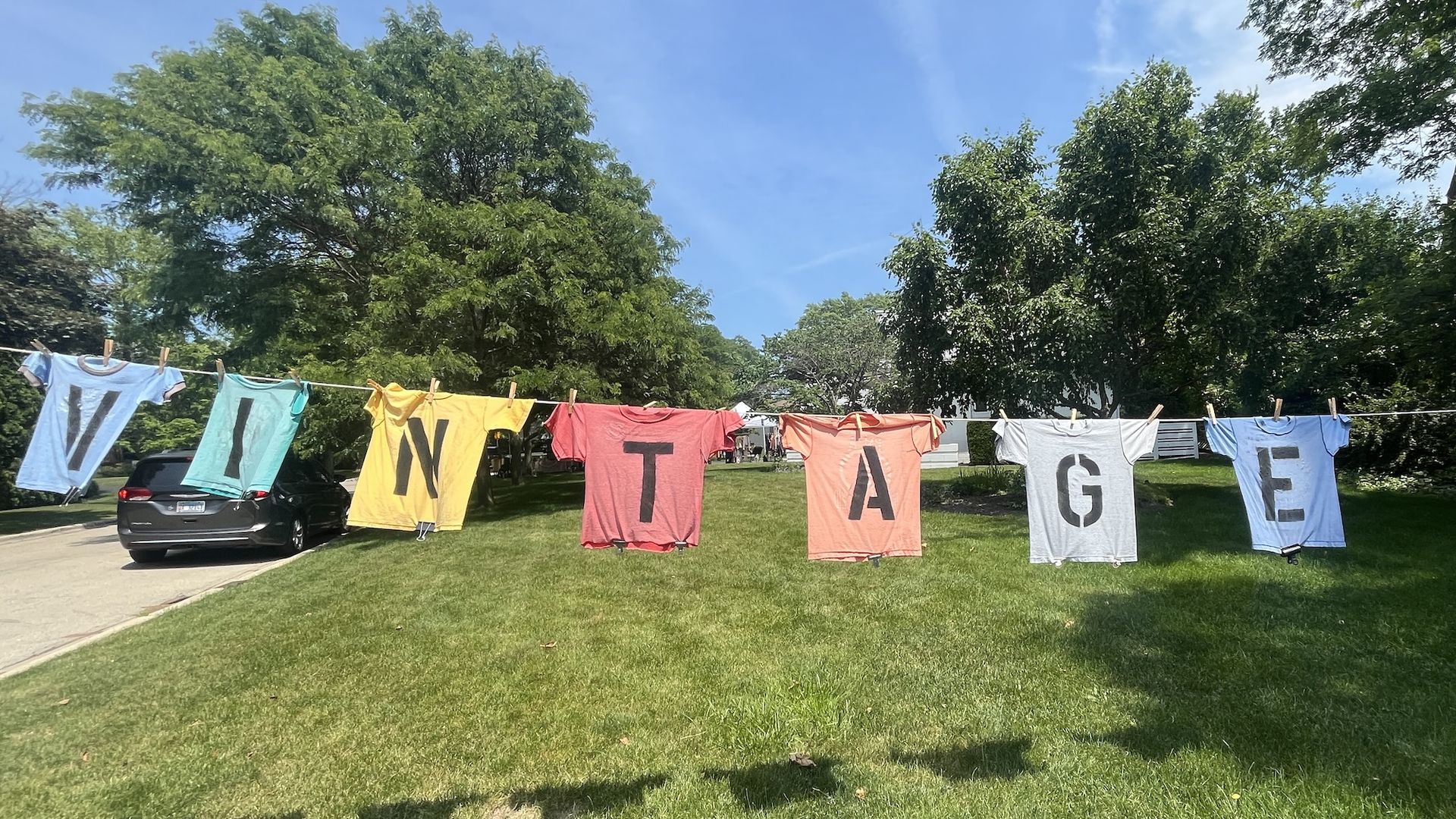 Different colored shirts on a clothes line each with a letter spelling Vintage