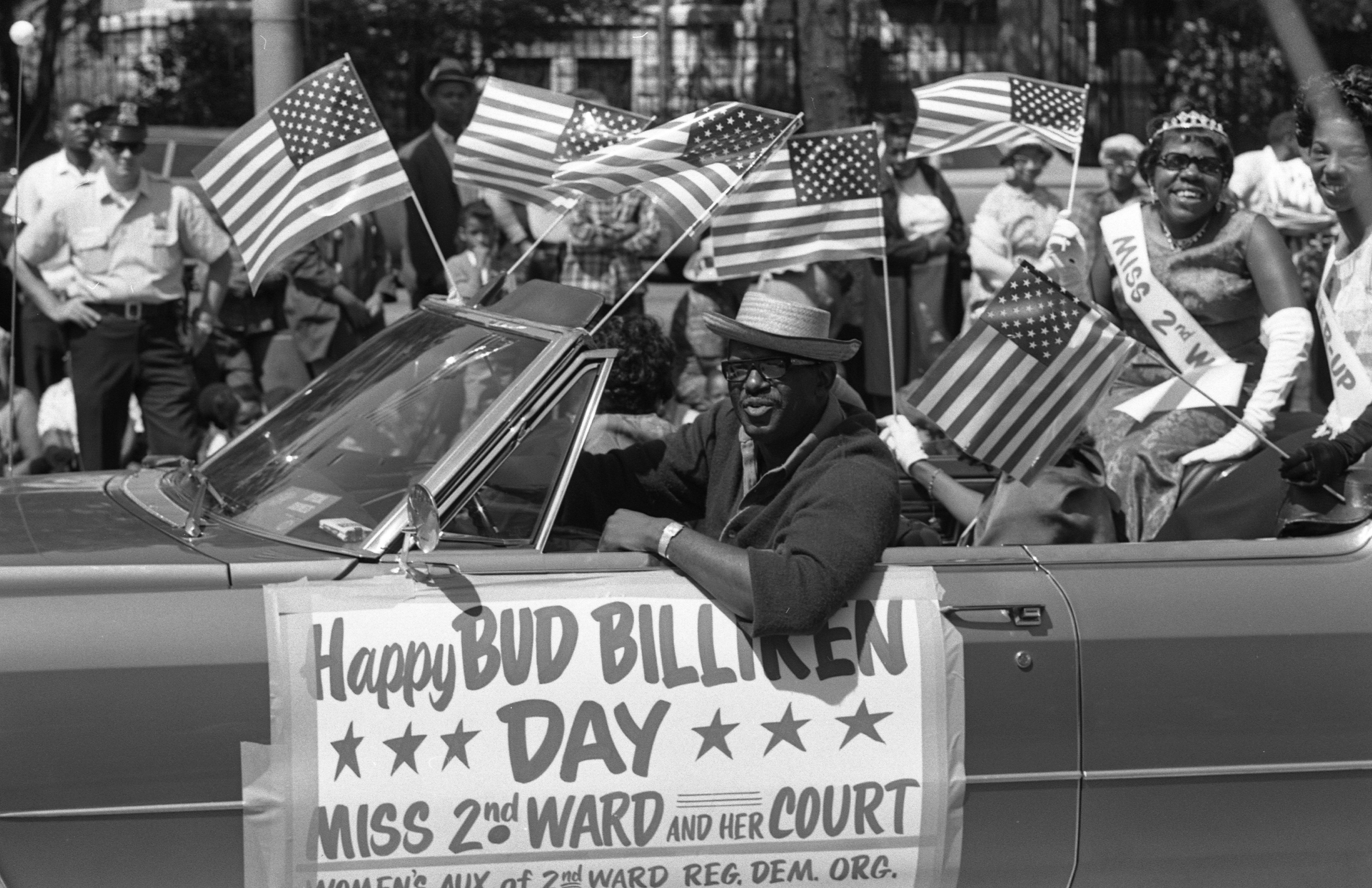 Miss 2nd Ward and her court smile and wave while riding in a convertible during the Bud Billiken Day parade.