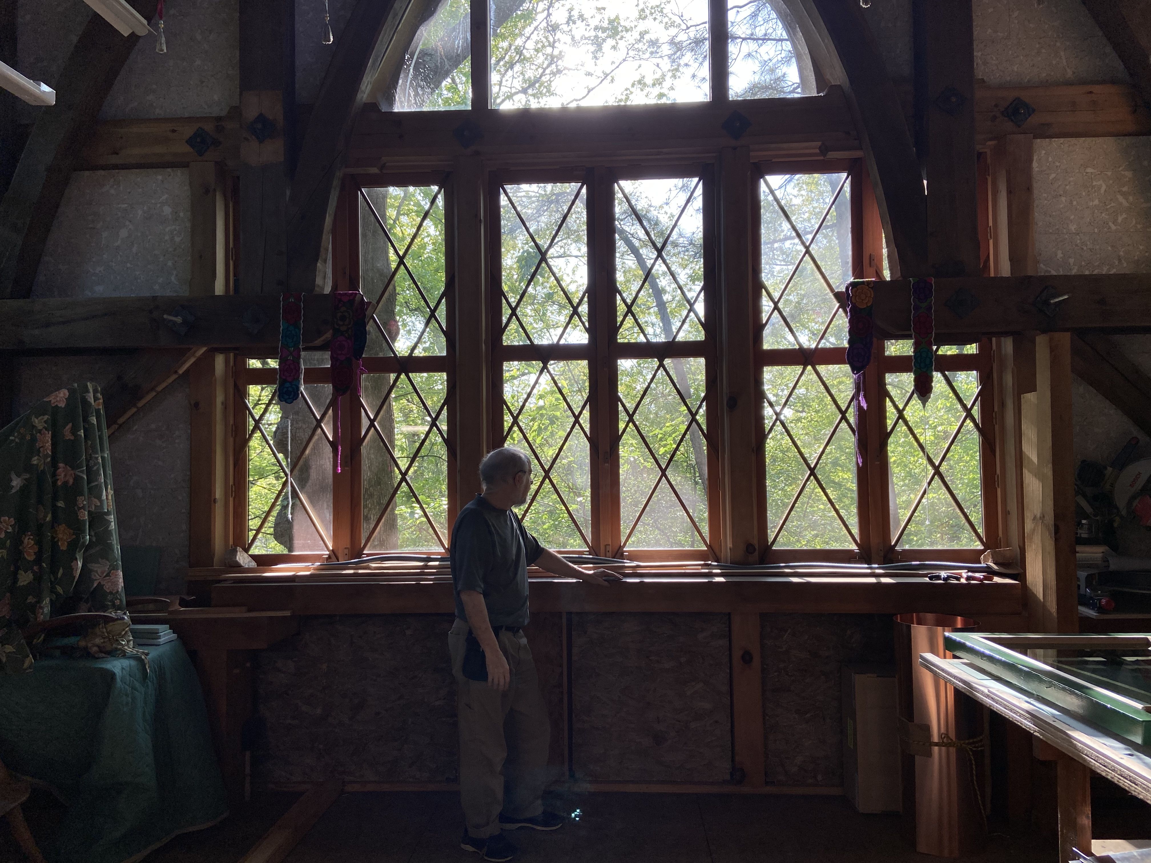 A man looks outside a large intricate window