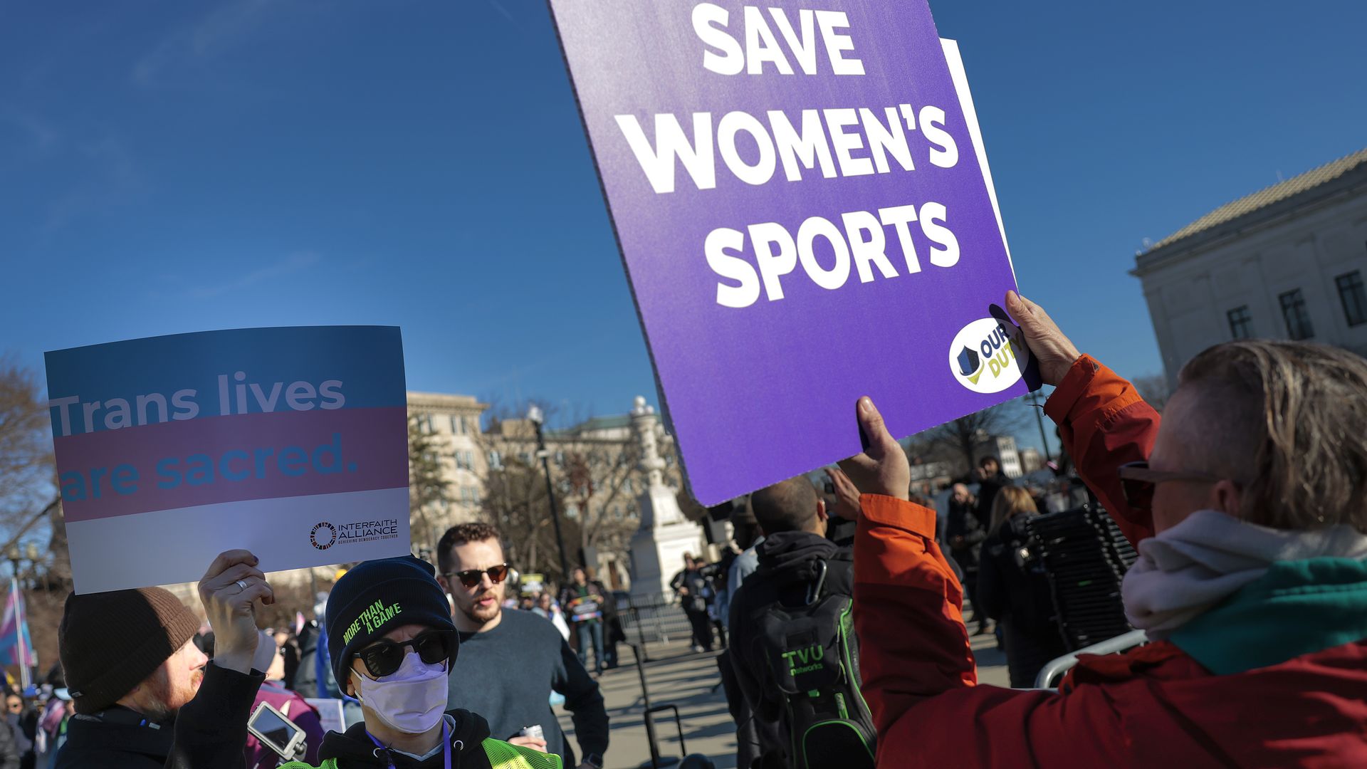 Demonstrators holding signs for opposing viewpoints on transgender athletes in girls’ and women’s sports gather outside the U.S. Supreme Court in Washington, D.C., during oral arguments in related cases.