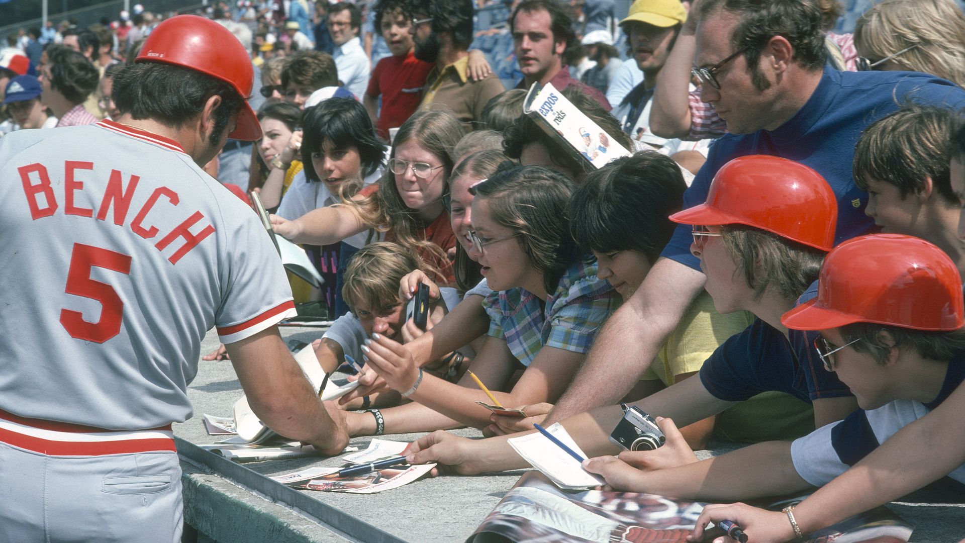 Cincinnati Reds catcher Johnny Bench signs autographs for children.