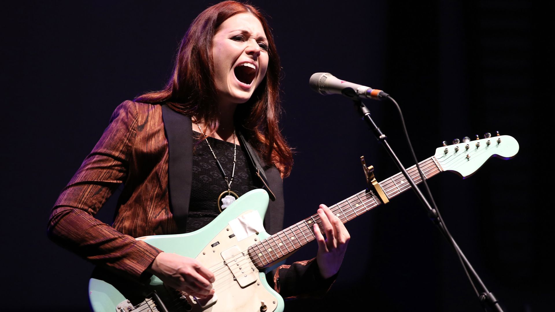 Rebecca Lovell of Larkin Poe strums her guitar while singing
