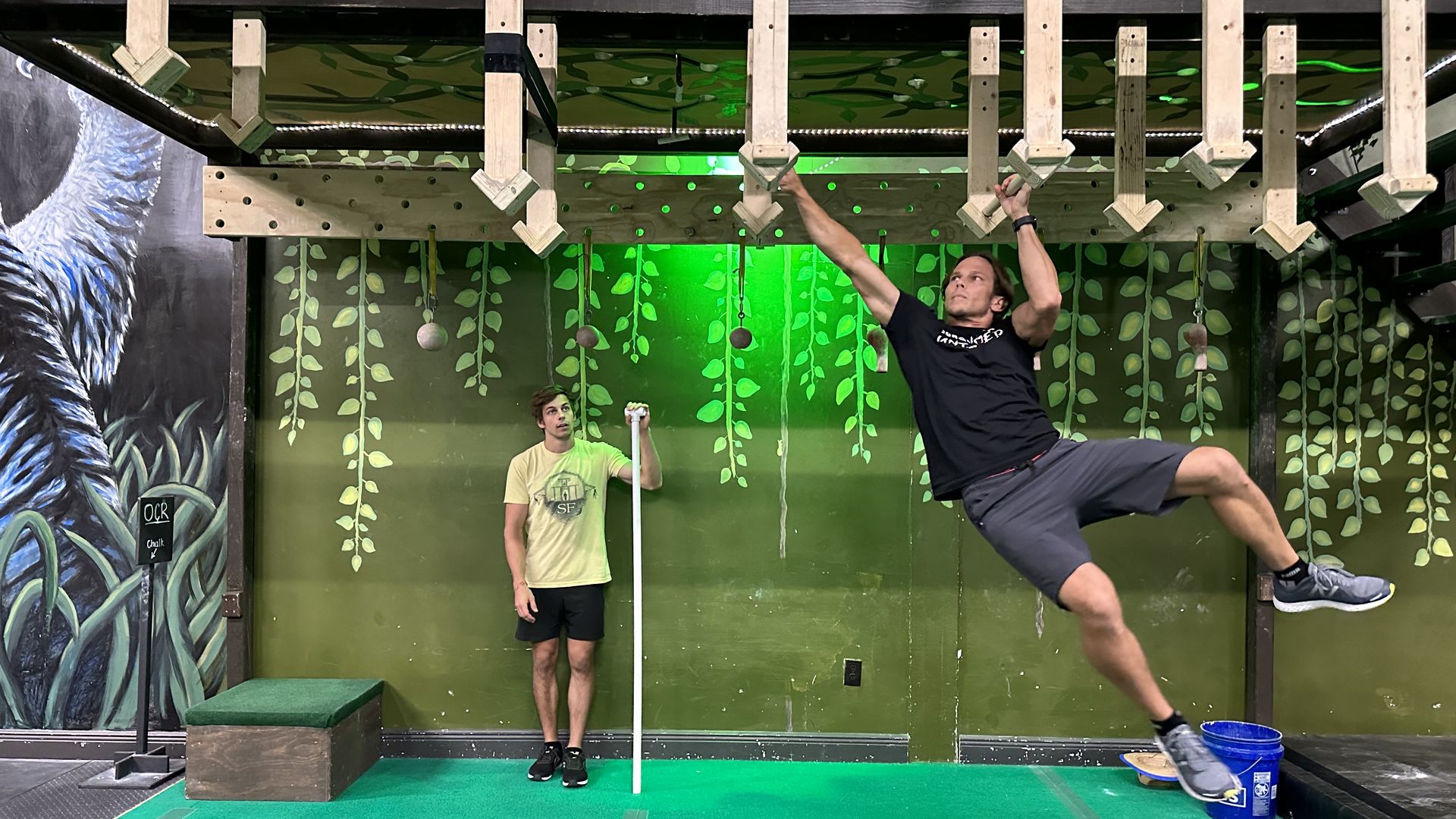 Jason Bergstrom moves through an obstacle as his son Caleb watches