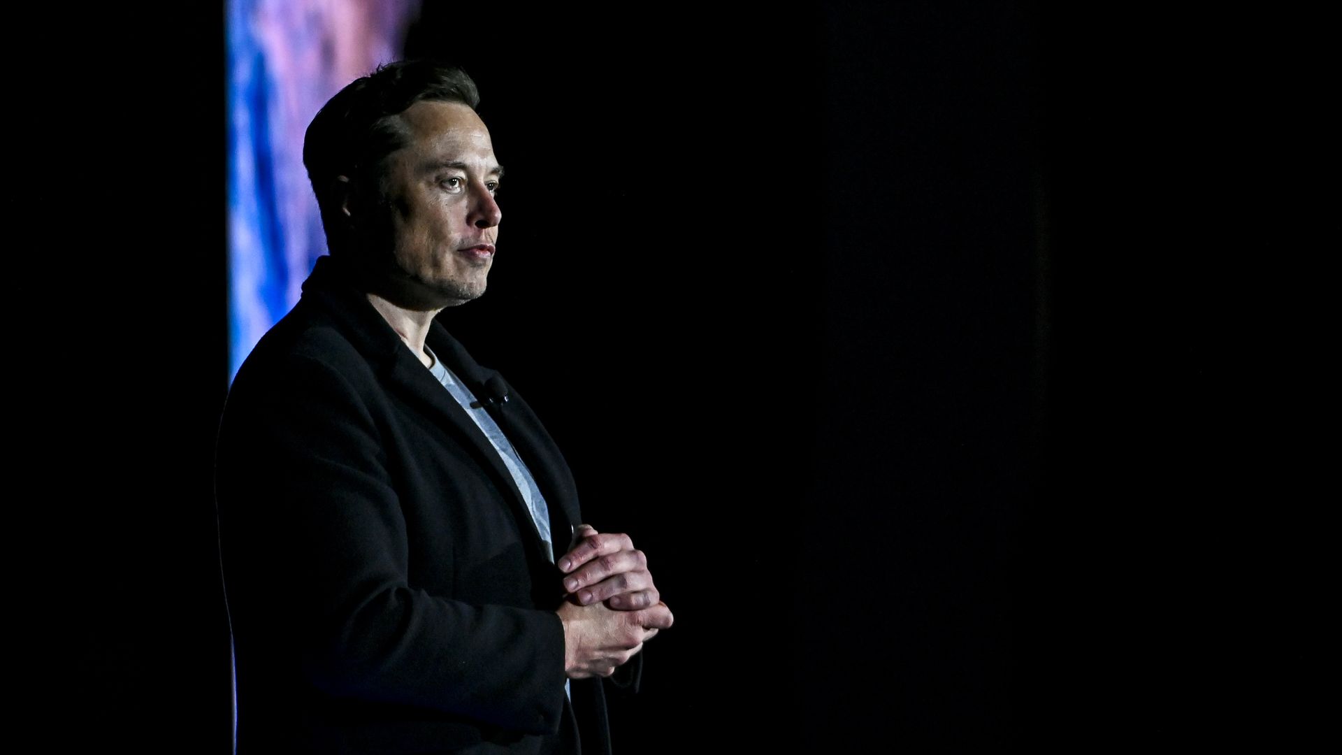 Elon Musk stands.