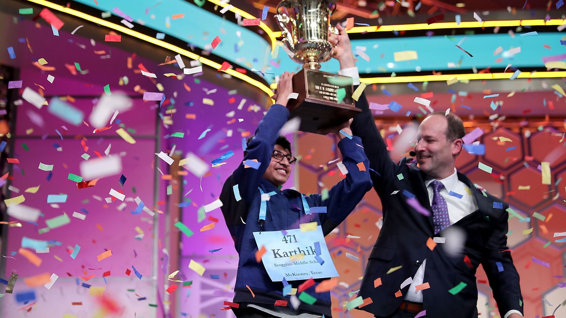 Karthik Nemmani poses with the championship trophy and E.W. Scripps Company CEO Adam Symson 