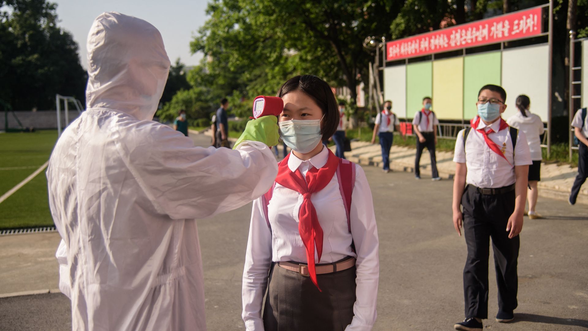 A pupil has her temperature taken as part of anti Covid-19 procedures before entering the Pyongyang Secondary School No. 1 in Pyongyang on June 22, 2021. 
