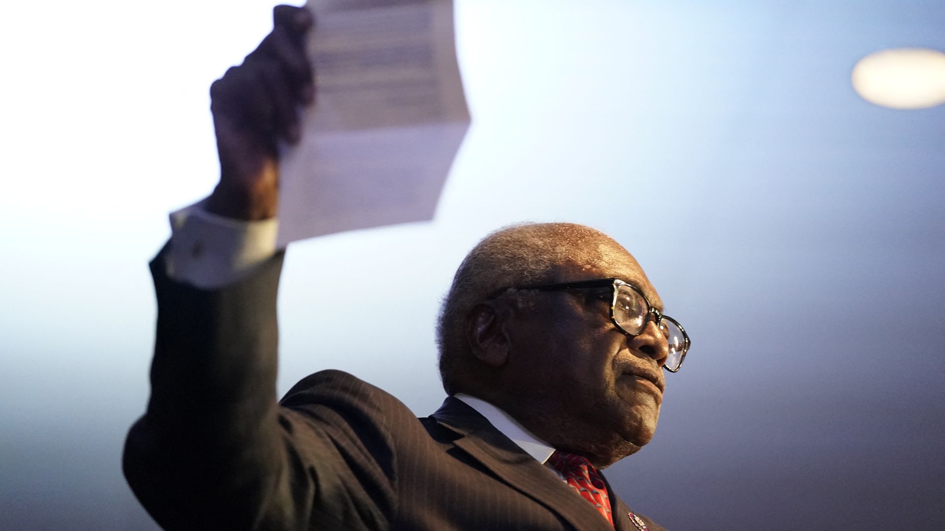 Clyburn holds a paper in his hand. The photo is taken from below.