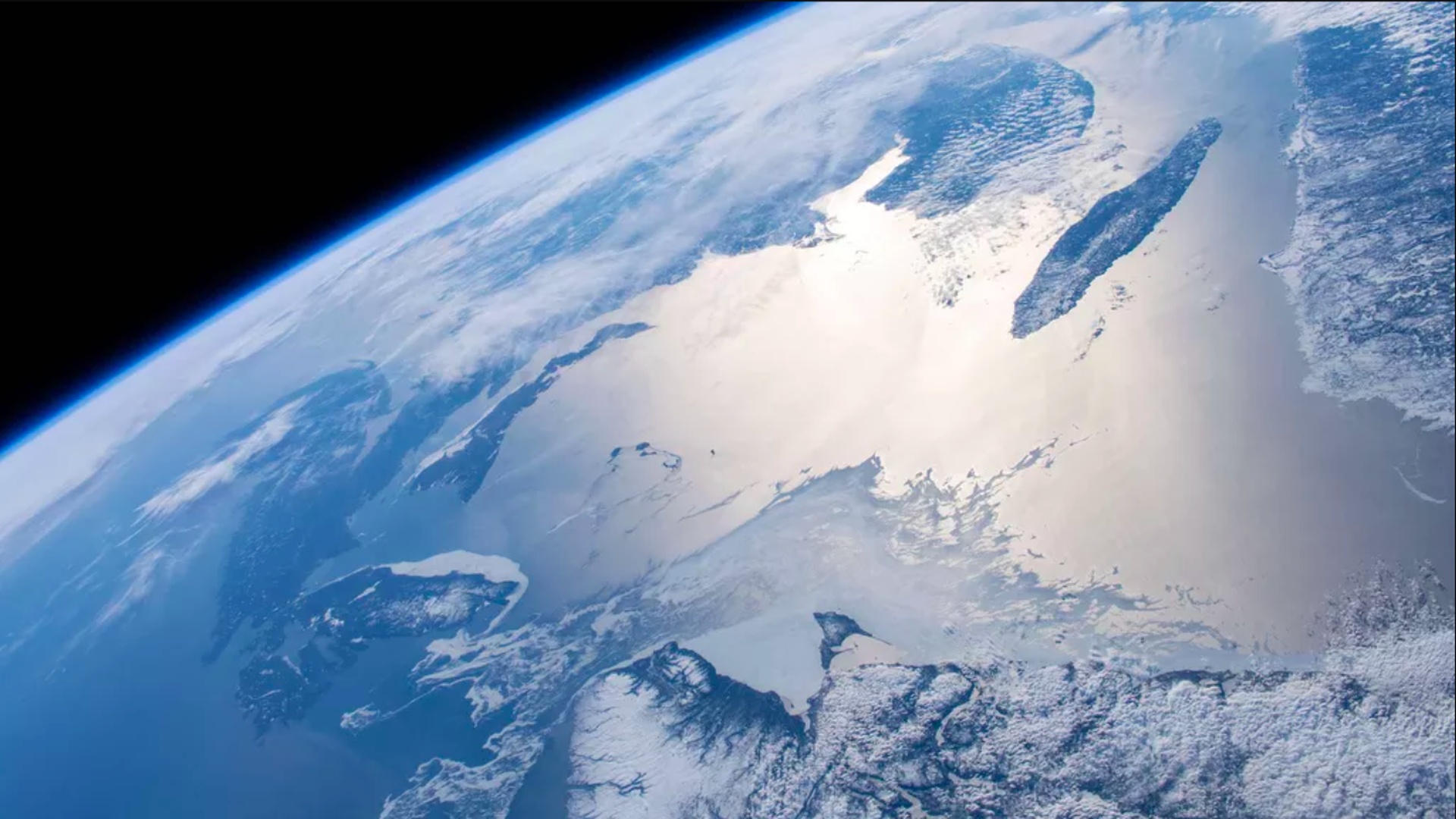 This image is a view of a quarter of the earth from space. It's mostly blue, with some glaciers. 