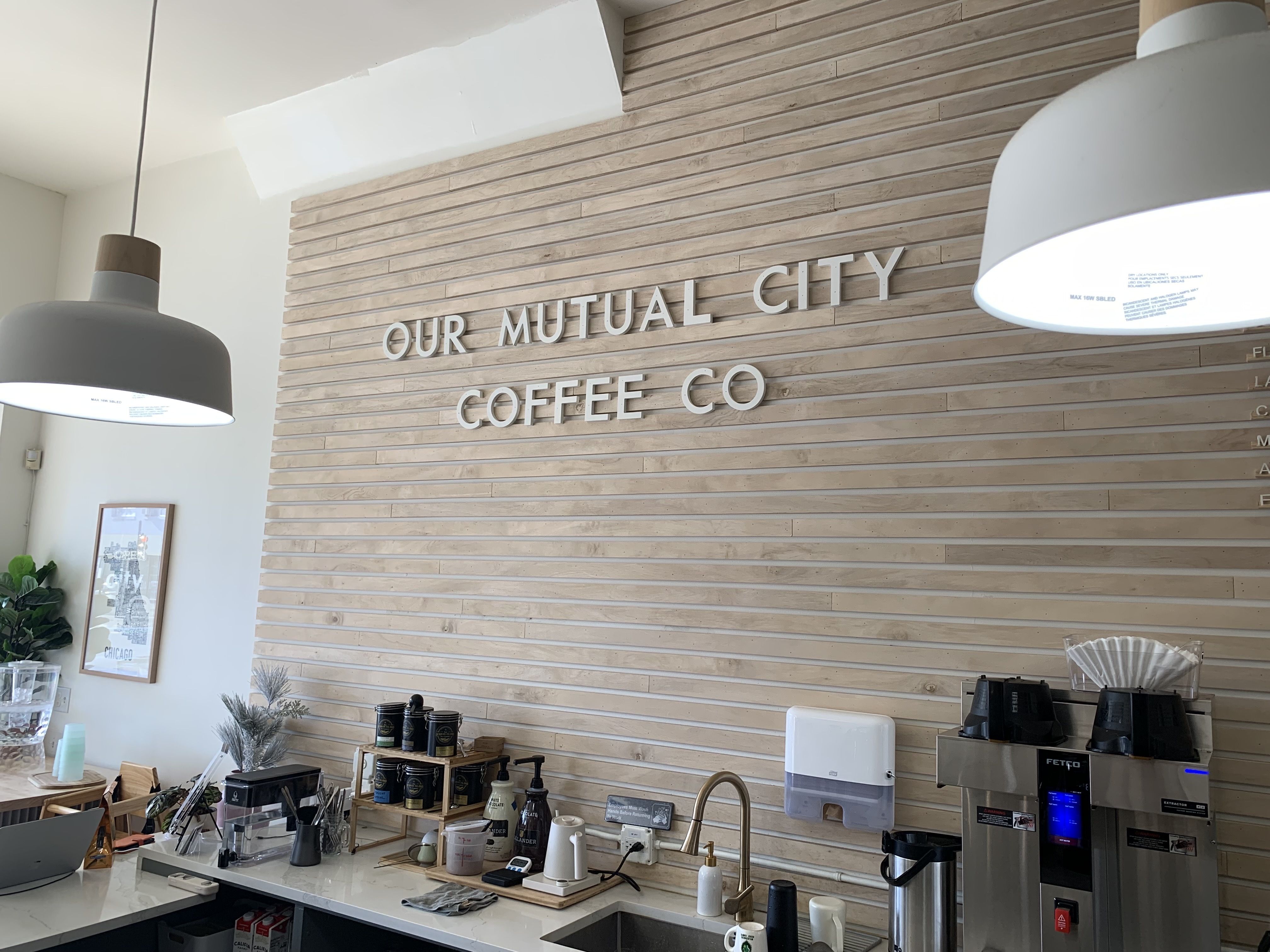 Photo of a wall at a coffee shop that says "Our Mutual City Coffee Co" 