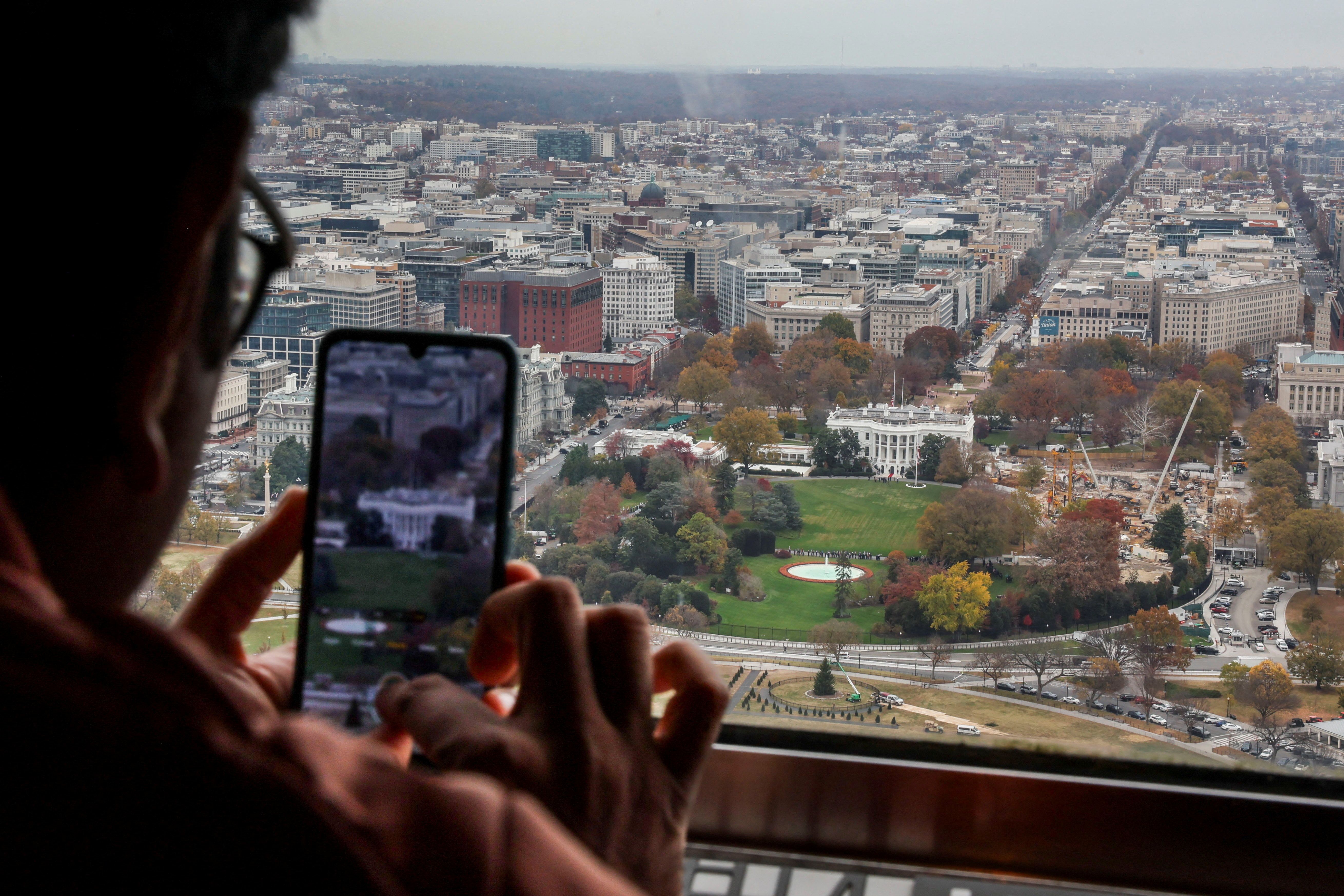 A tourist observes demolition of the East Wing of the White House during construction of U.S. President Donald Trump's proposed ballroom from the top of the reopened Washington Monument, following the longest shutdown of the government in Washington, D.C., U.S., November 15, 2025. REUTERS/ Jessica K