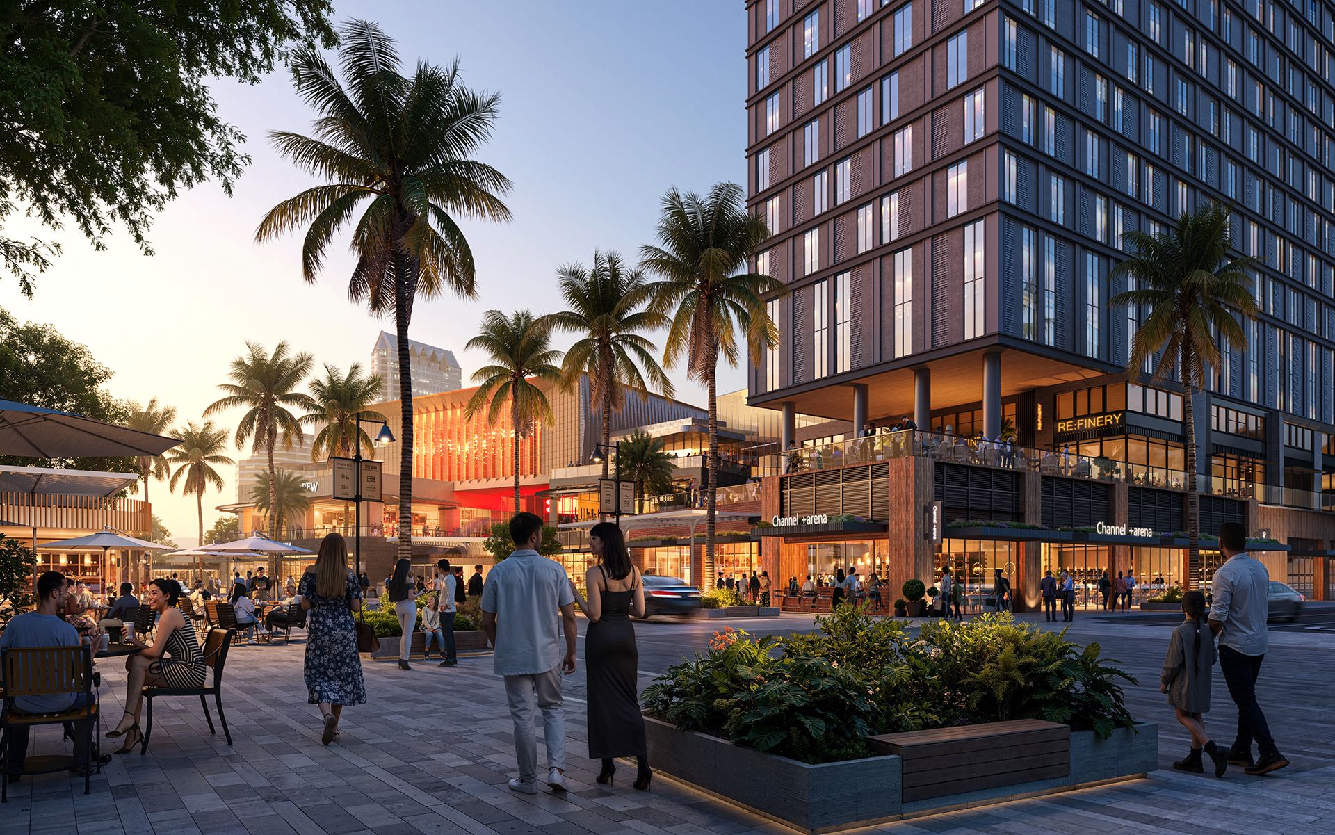 People stroll and dine outdoors at a lively urban plaza with palm trees, modern shops including "Channel +arena" and "RE:FINERY," and a tall building at sunset.