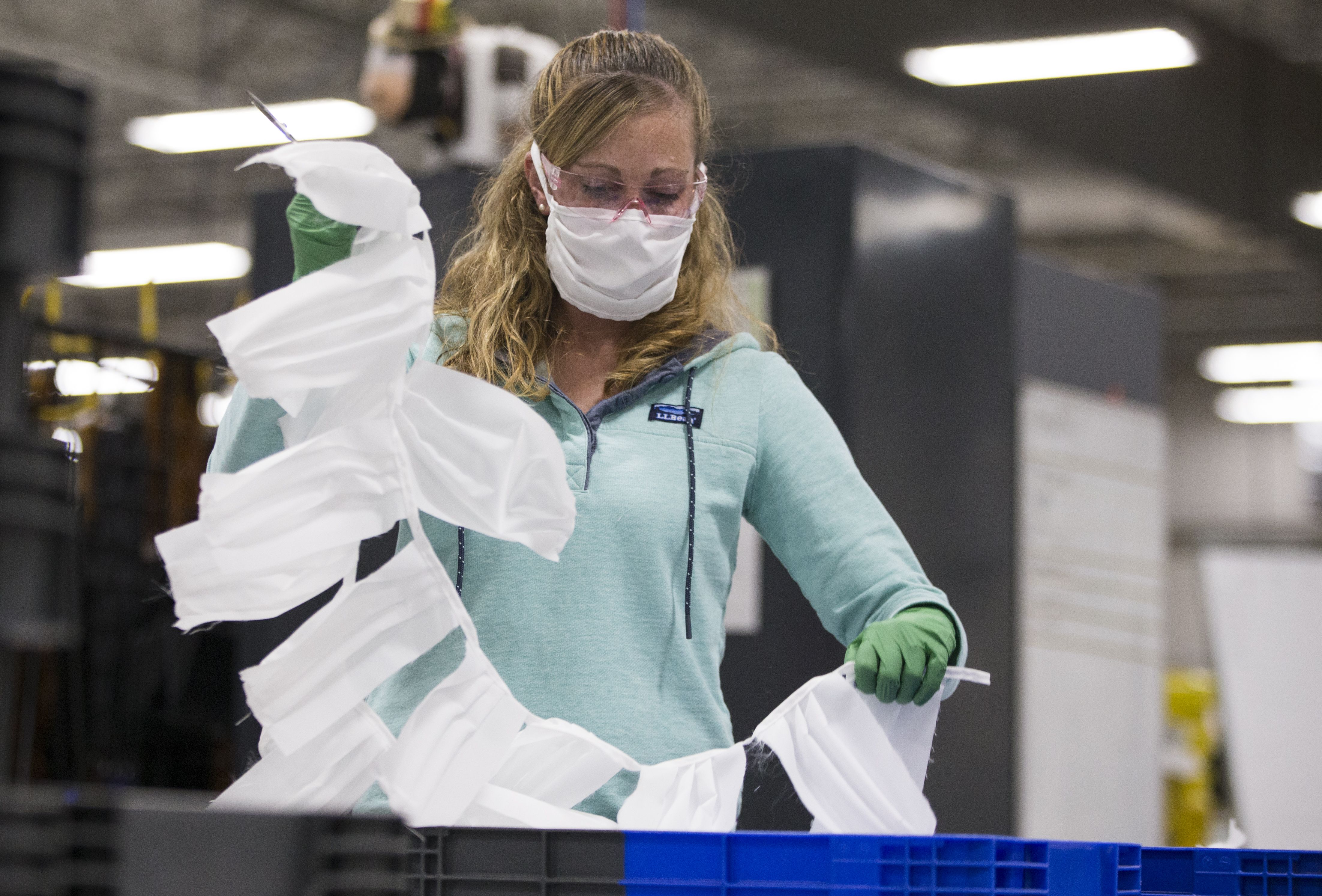 Sarah Dodson holds up a string of uncut masks at the L.L. Bean plant in Brunswick, ME