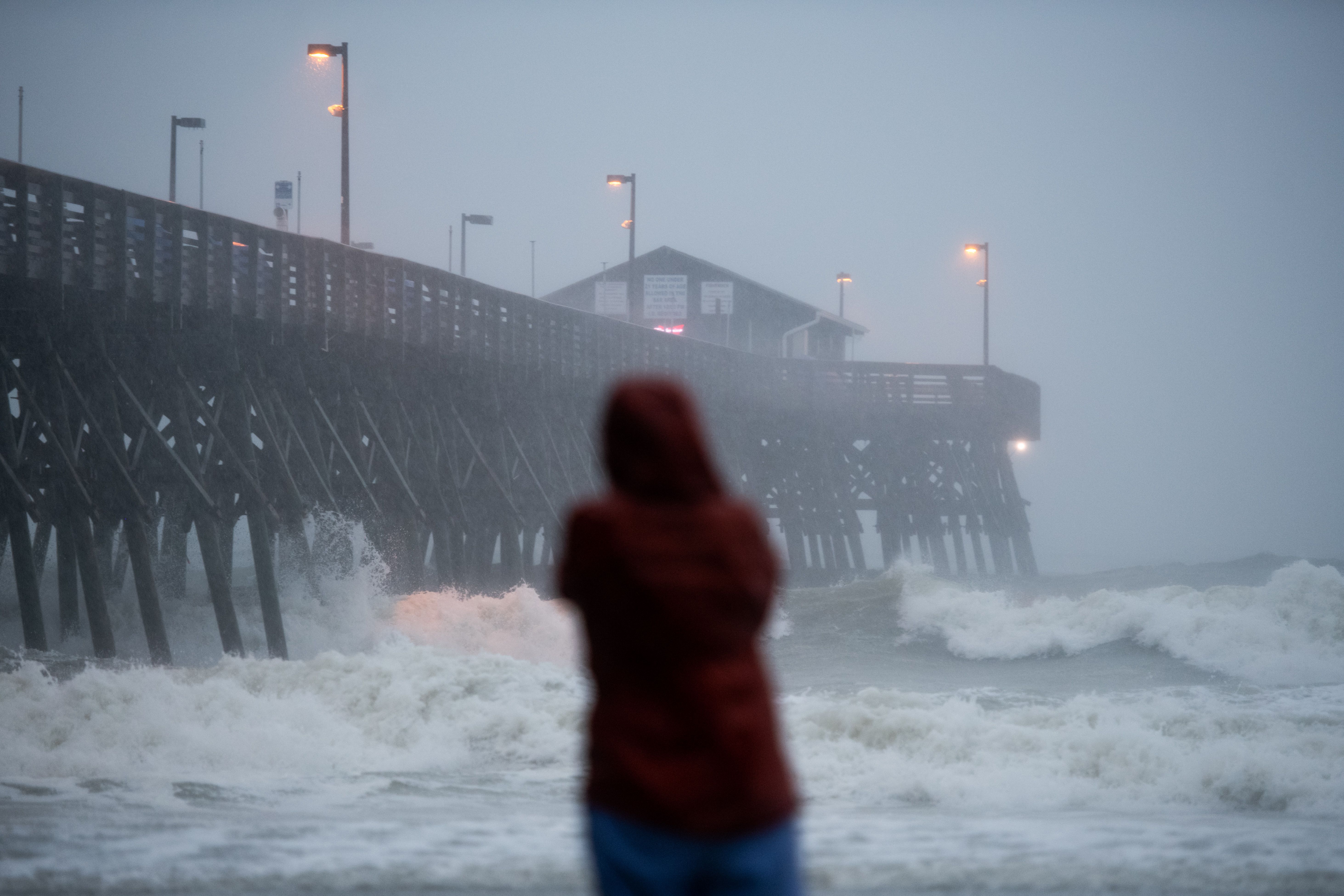 A person watches waves crashing against the Pier at Garden City August 3, 2020 in Garden City, South Carolina.