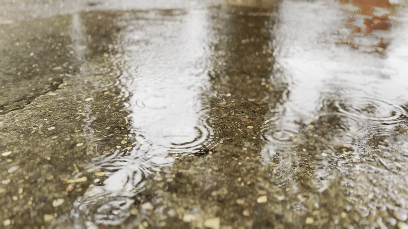 Animated gif shows raindrops falling in a puddle. 