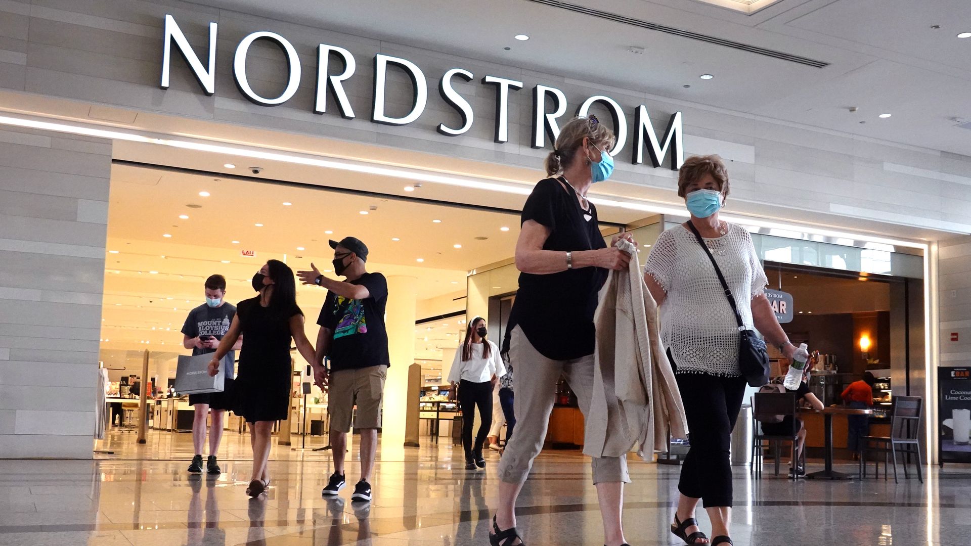 Masked shoppers leave a Nordstrom store in a mall