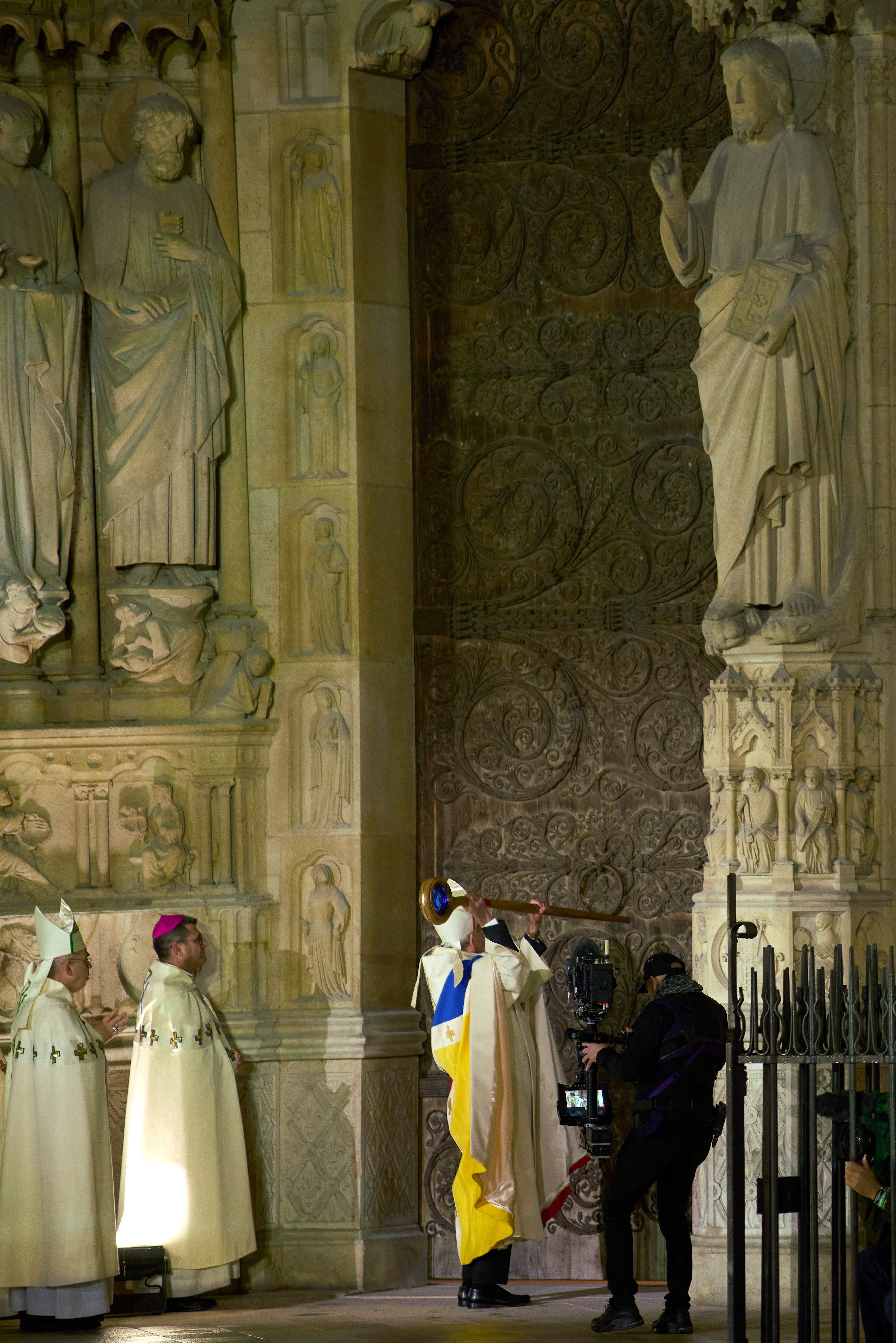 PARIS, FRANCE - DECEMBER 07: Archbishop of Paris, Laurent Ulrich, knocks on the door of Notre-Dame of Paris Cathedral during the ceremony to mark the reopening of Notre-Dame of Paris Cathedral on December 07, 2024 in Paris, France. After five years of restoration, Notre-Dame Cathedral in Paris reope