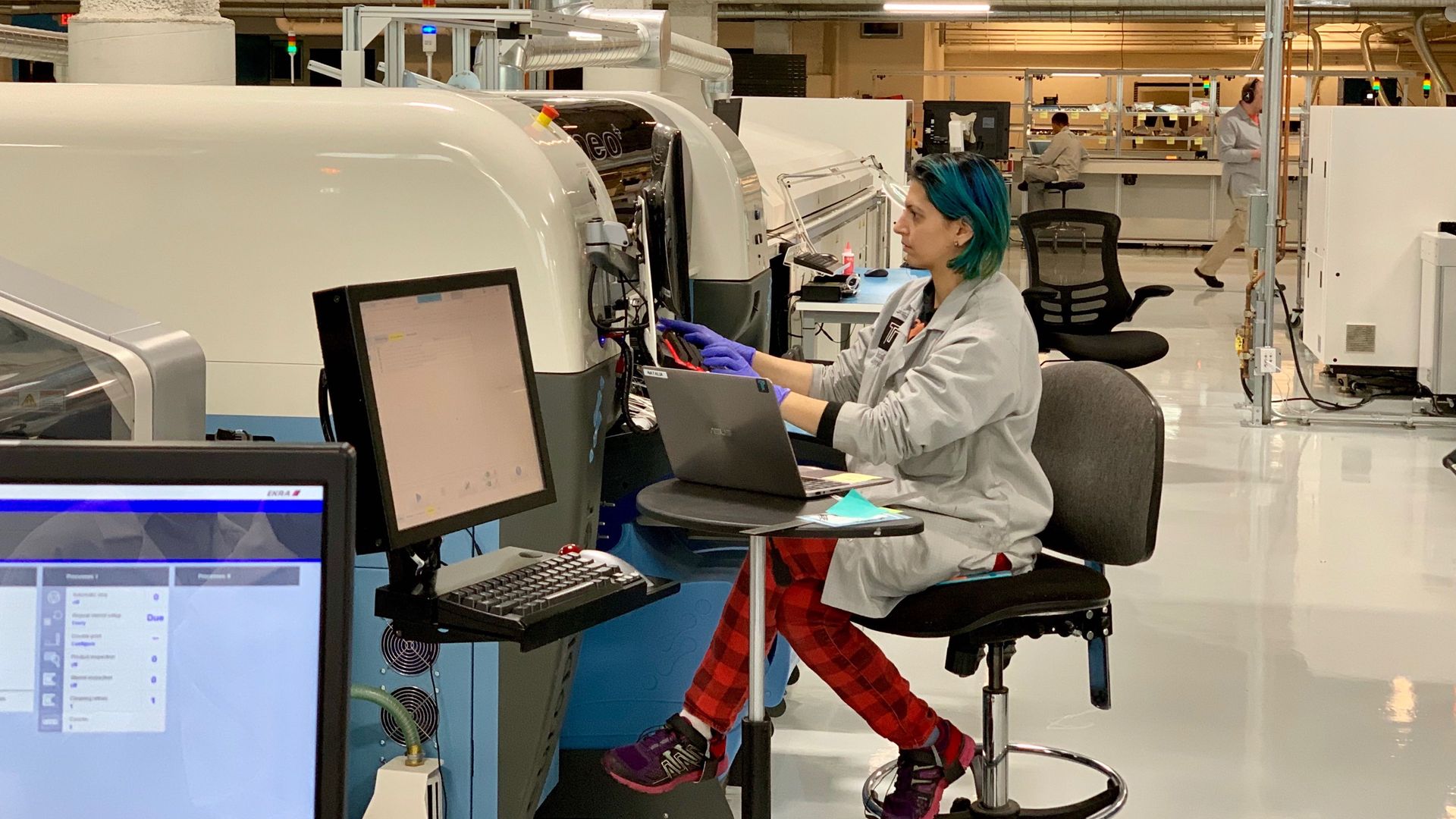 A Tempo Automation employee prepares a circuit board assembly machine. 
