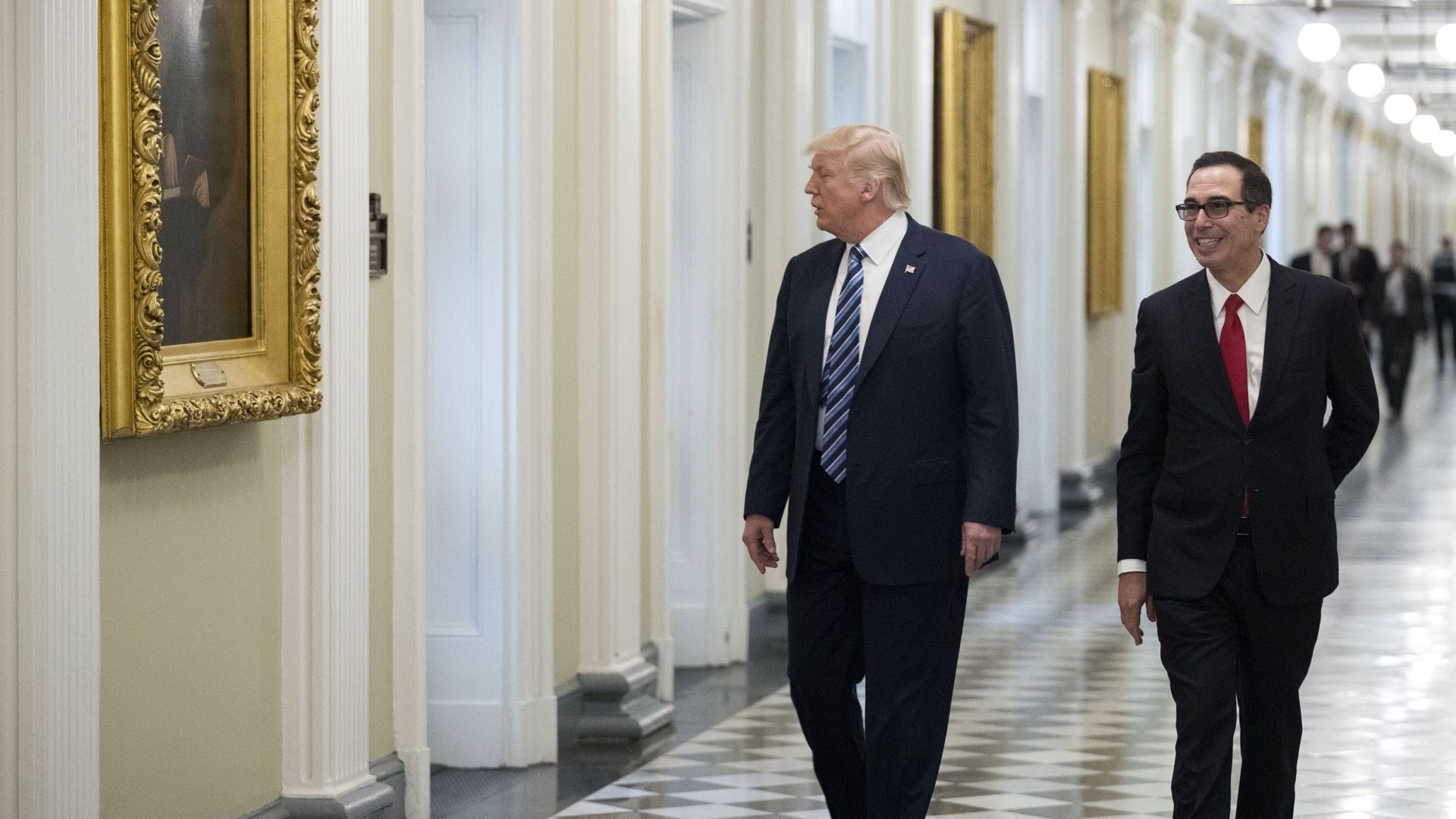 Treasury Secretary Steven Mnuchin walks down a hallway with President Trump