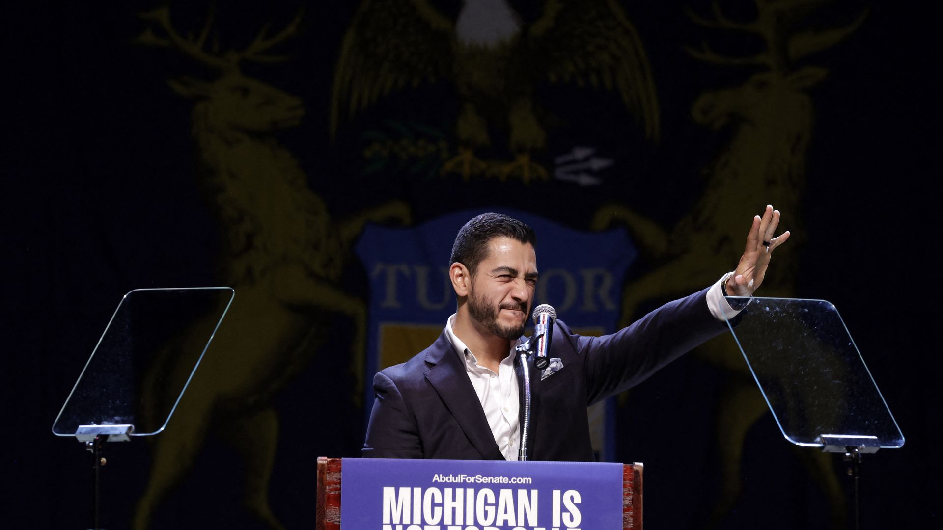 Abdul El-Sayed waves to a crowd from behind a podium.
