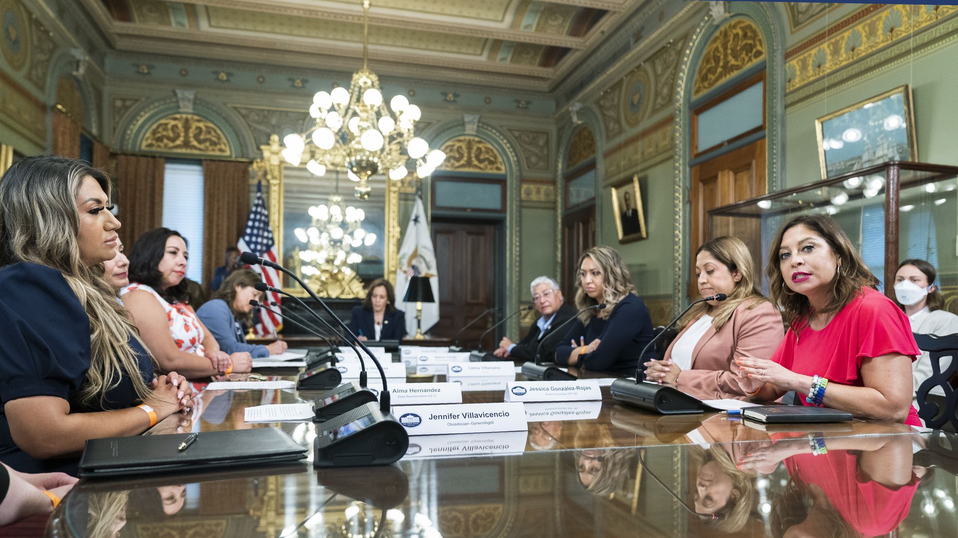 A group of Latina lawmakers talking at a table.