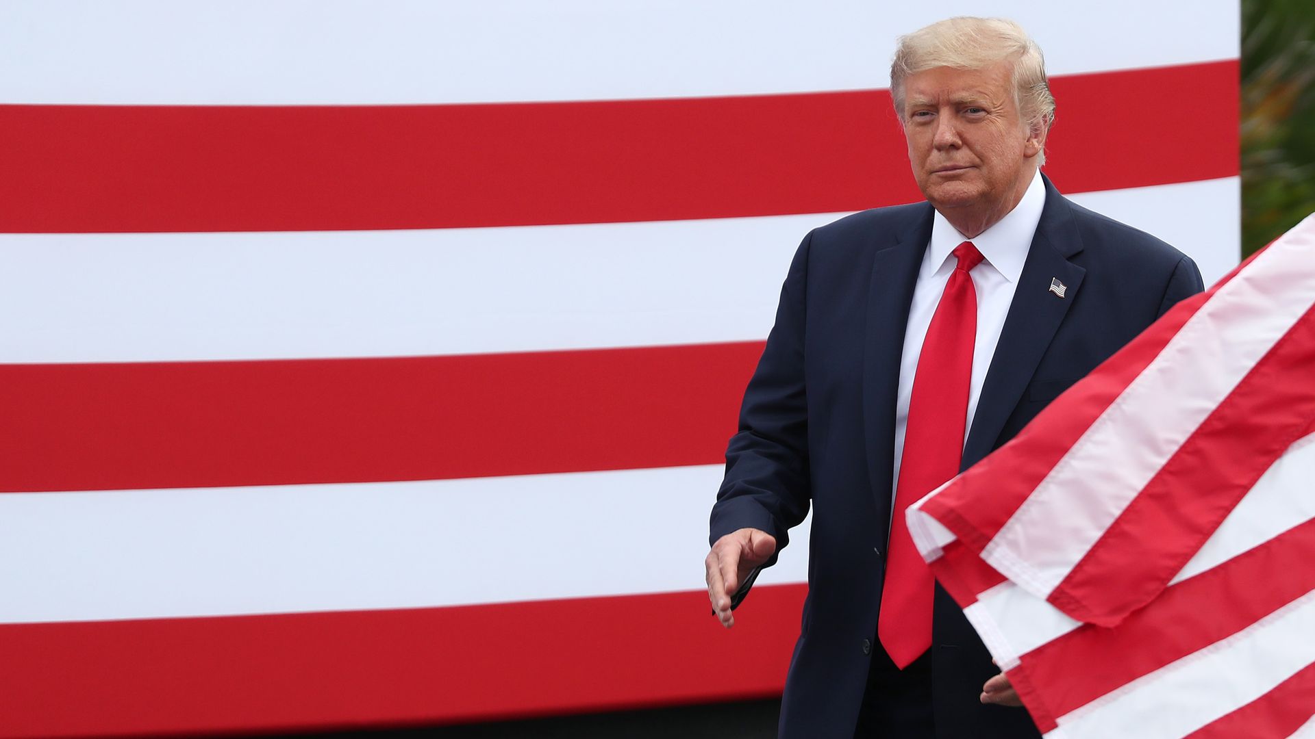 Trump walking through flags