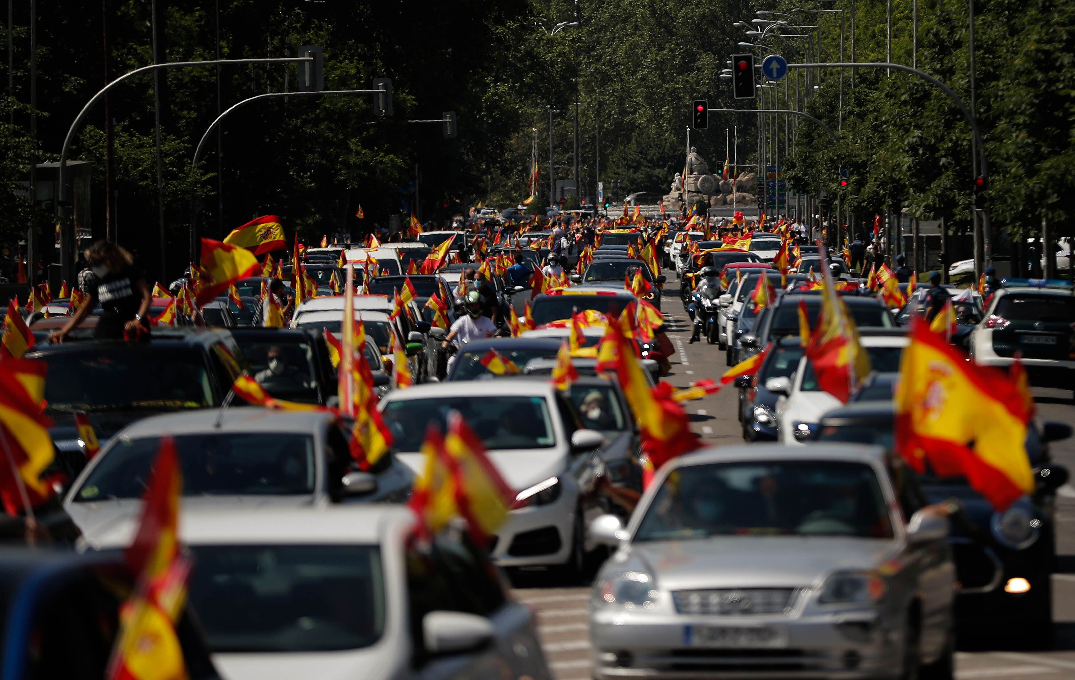 In this image, Spanish flags wave from several long lines of cars