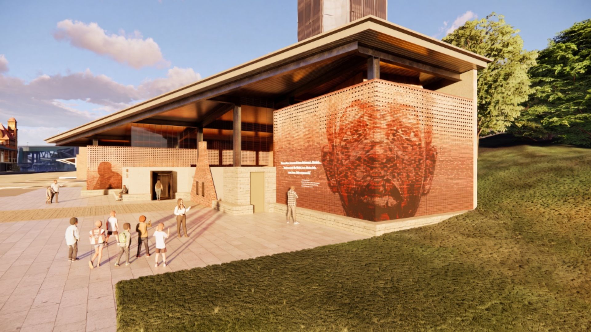 A modern brick building with a slanted roof and a large perforated brick wall featuring a red mural of a face. People walk on a tiled plaza beside green grass and trees under a blue sky.