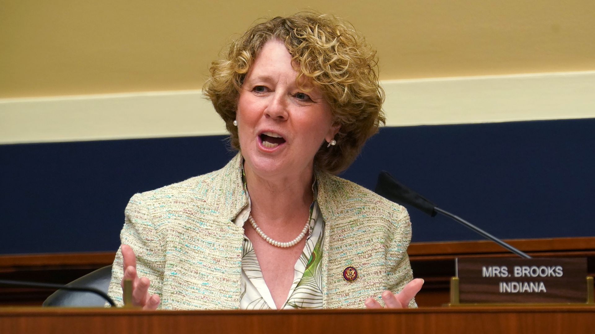 A woman in a suit at a microphone. 