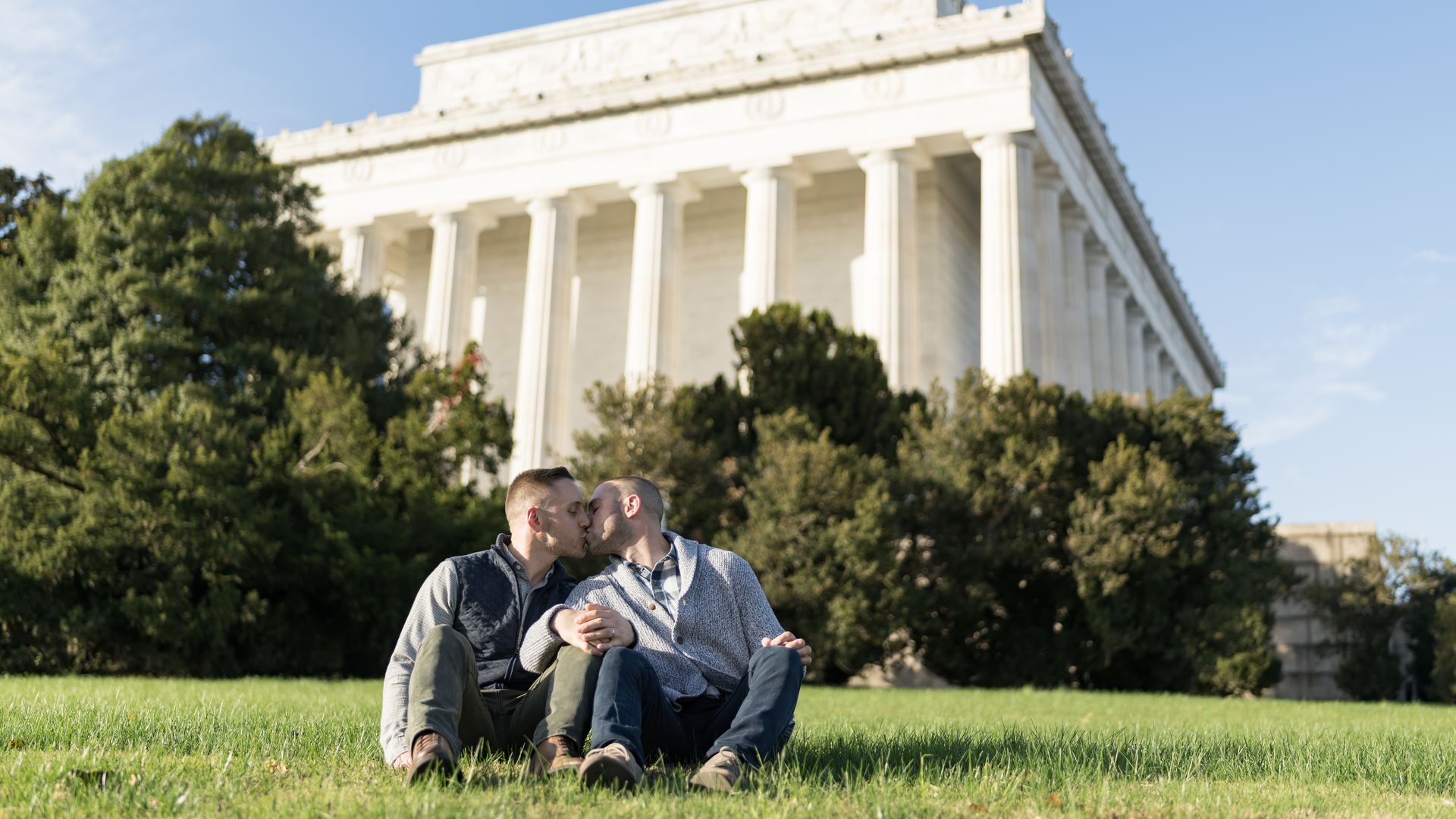 A couple kissing on the Lincoln Memorial lawn.