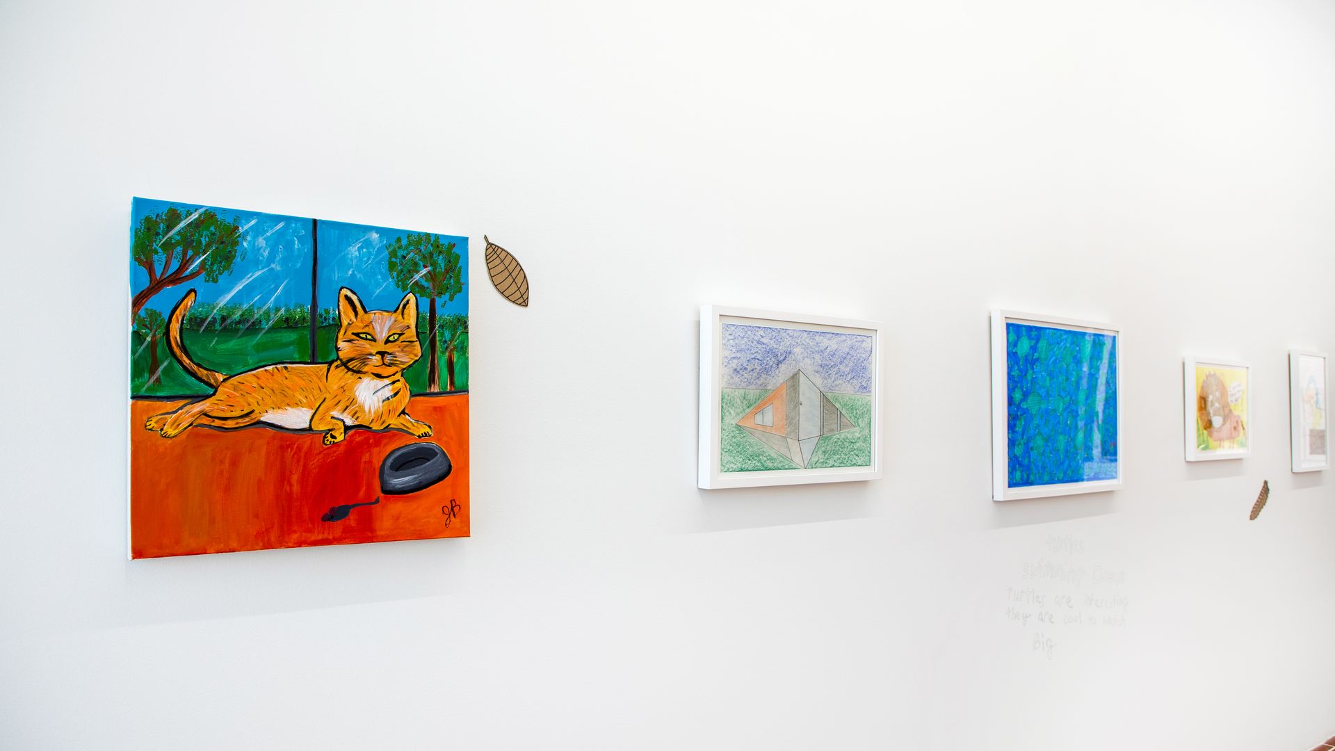 Four brightly colored paintings on a wall