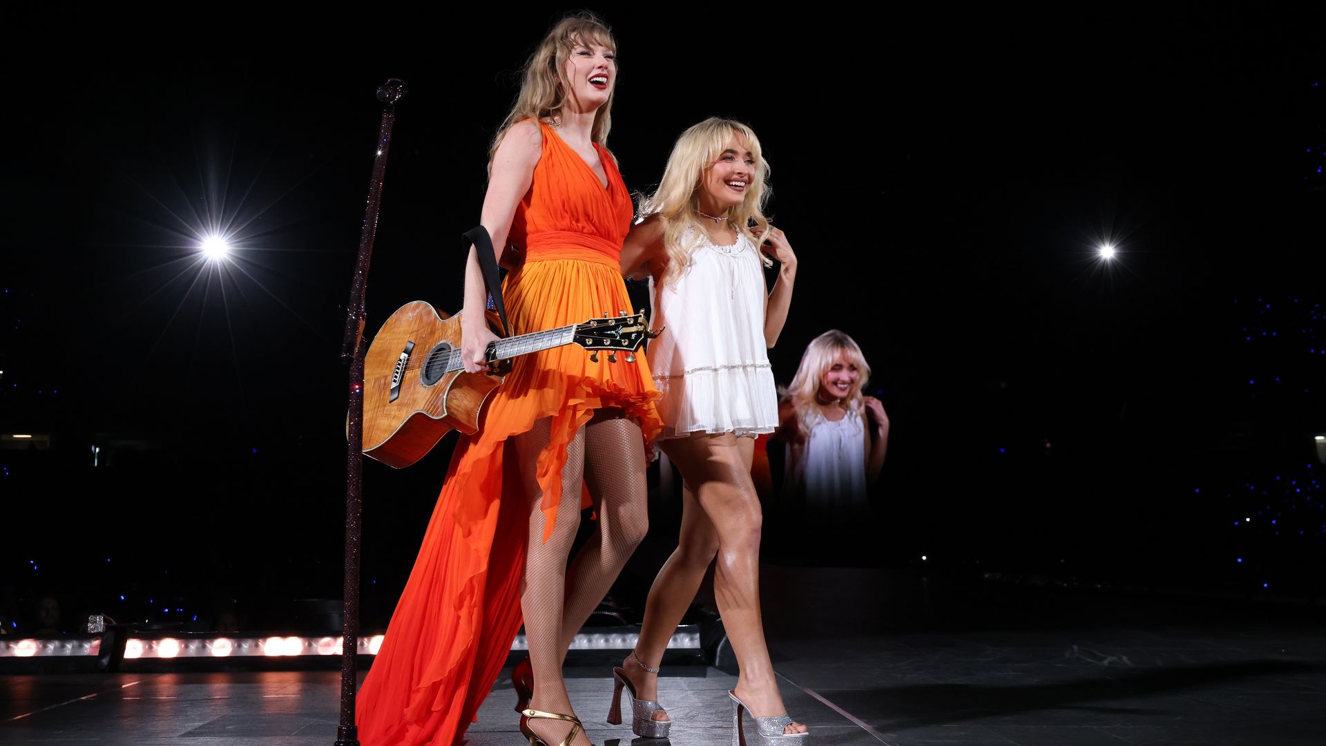 Photo shows Taylor Swift and Sabrina Carpenter on stage.