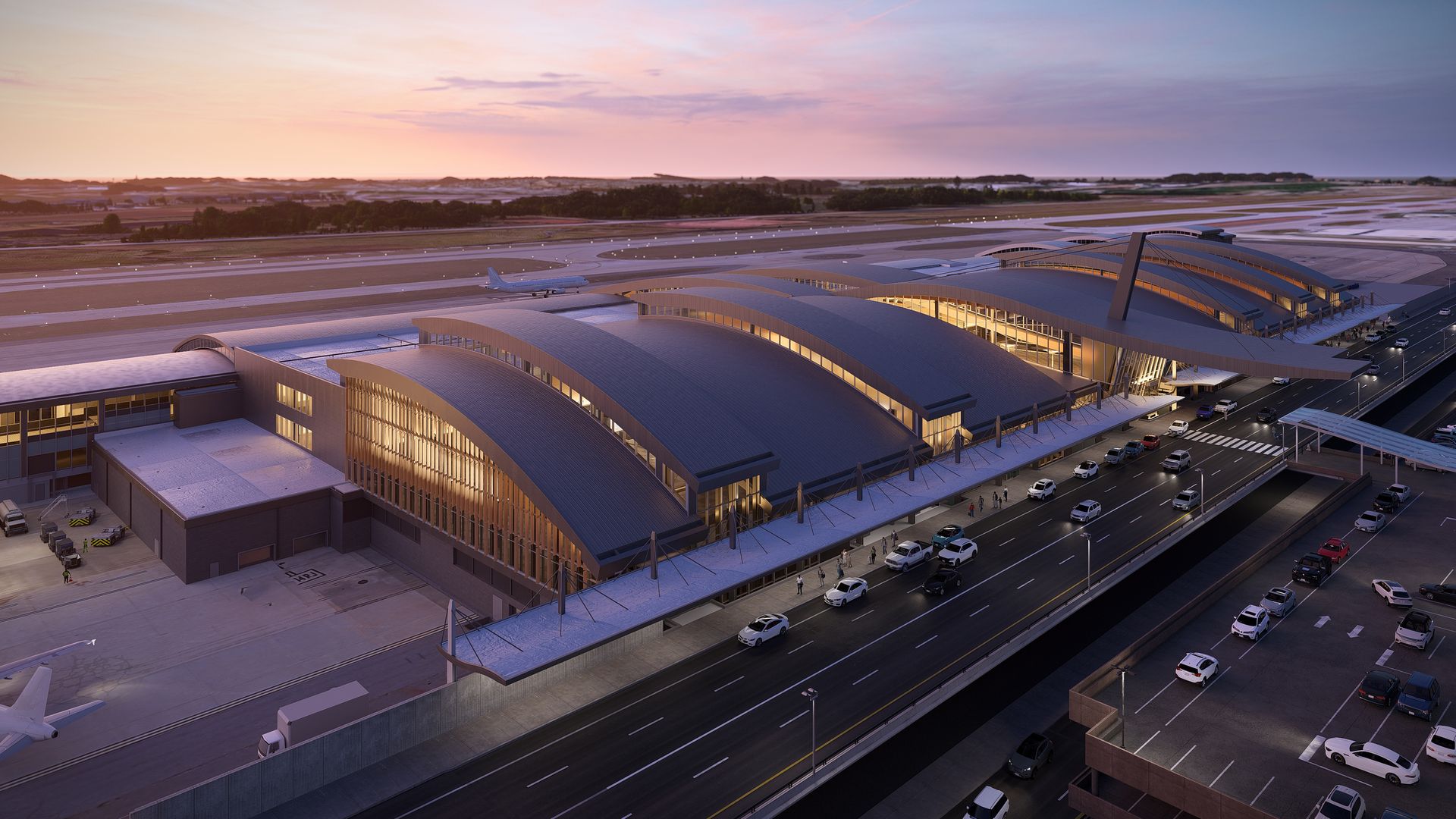 Aerial view of a modern airport terminal with curved roofs glowing warmly at sunset, multiple cars parked and driving on the road outside, and an airplane on the runway.