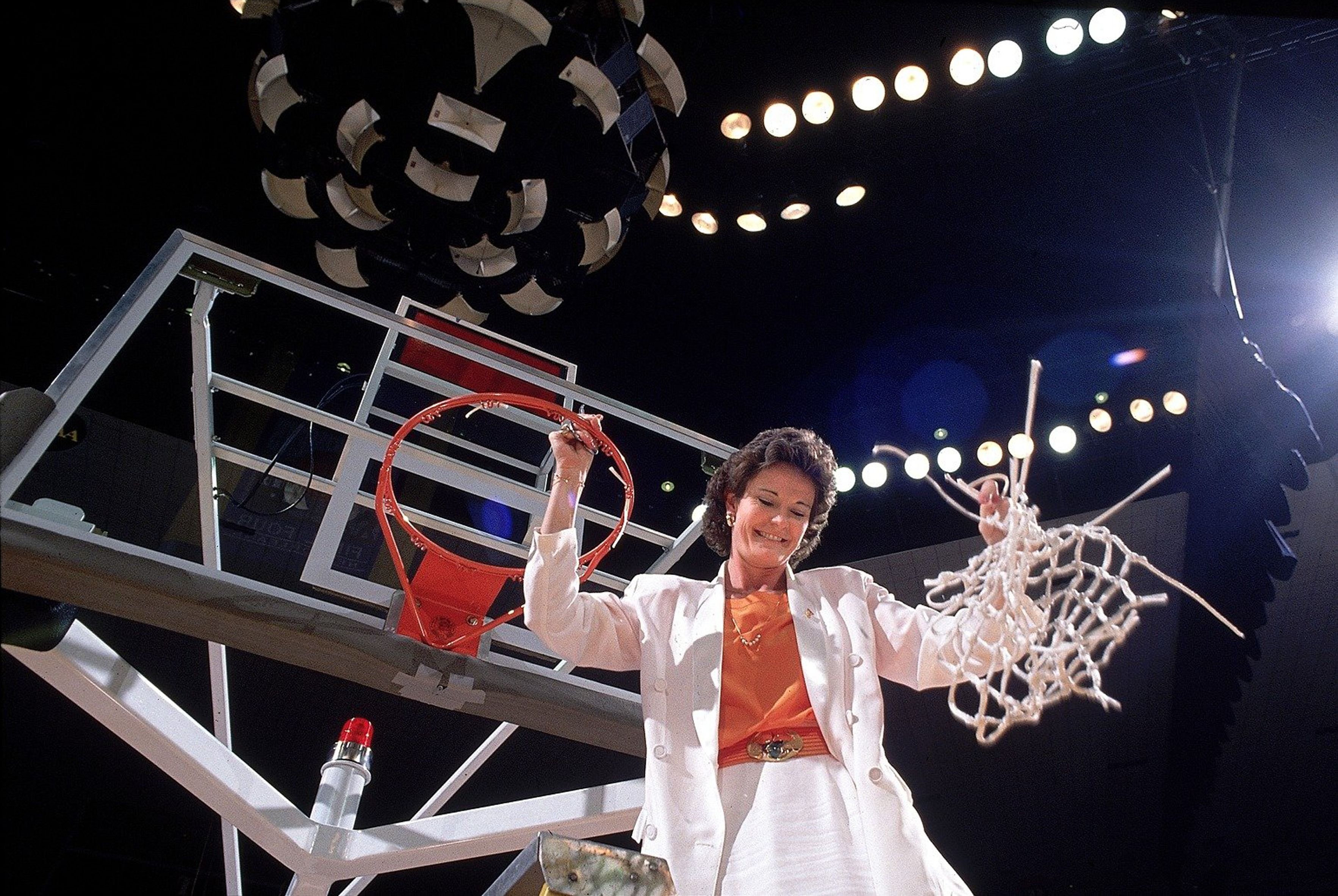 Coach Pat Summitt cuts the net off a basketball hoop.