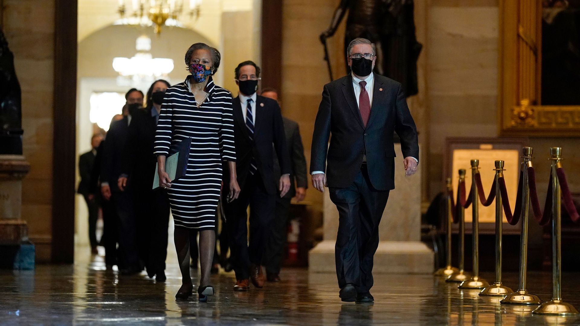 House Impeachment managers accompany the formal Articles of Impeachment of former US President Donald Trump as they walk through the Rotunda to deliver them to the US Senate