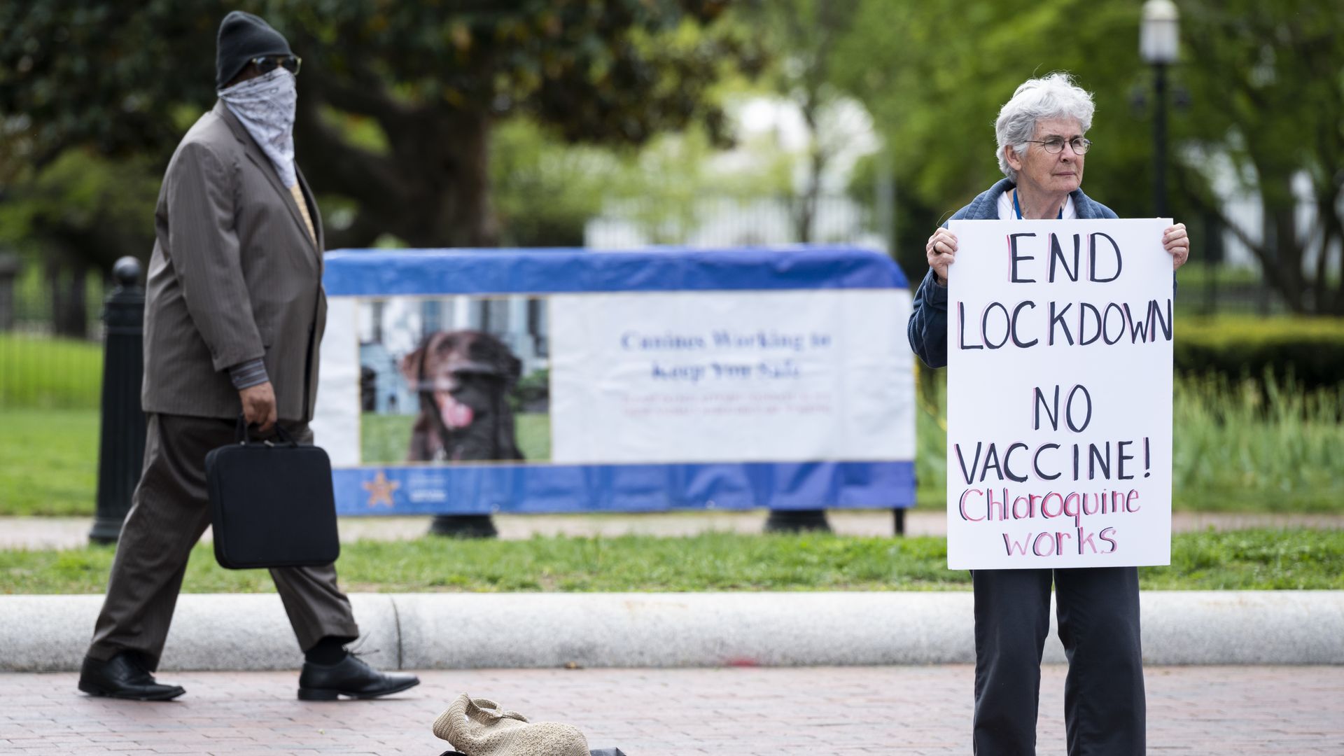 A lone protester holds a sign calling for an end to the lockdown and claiming chloroquine works 