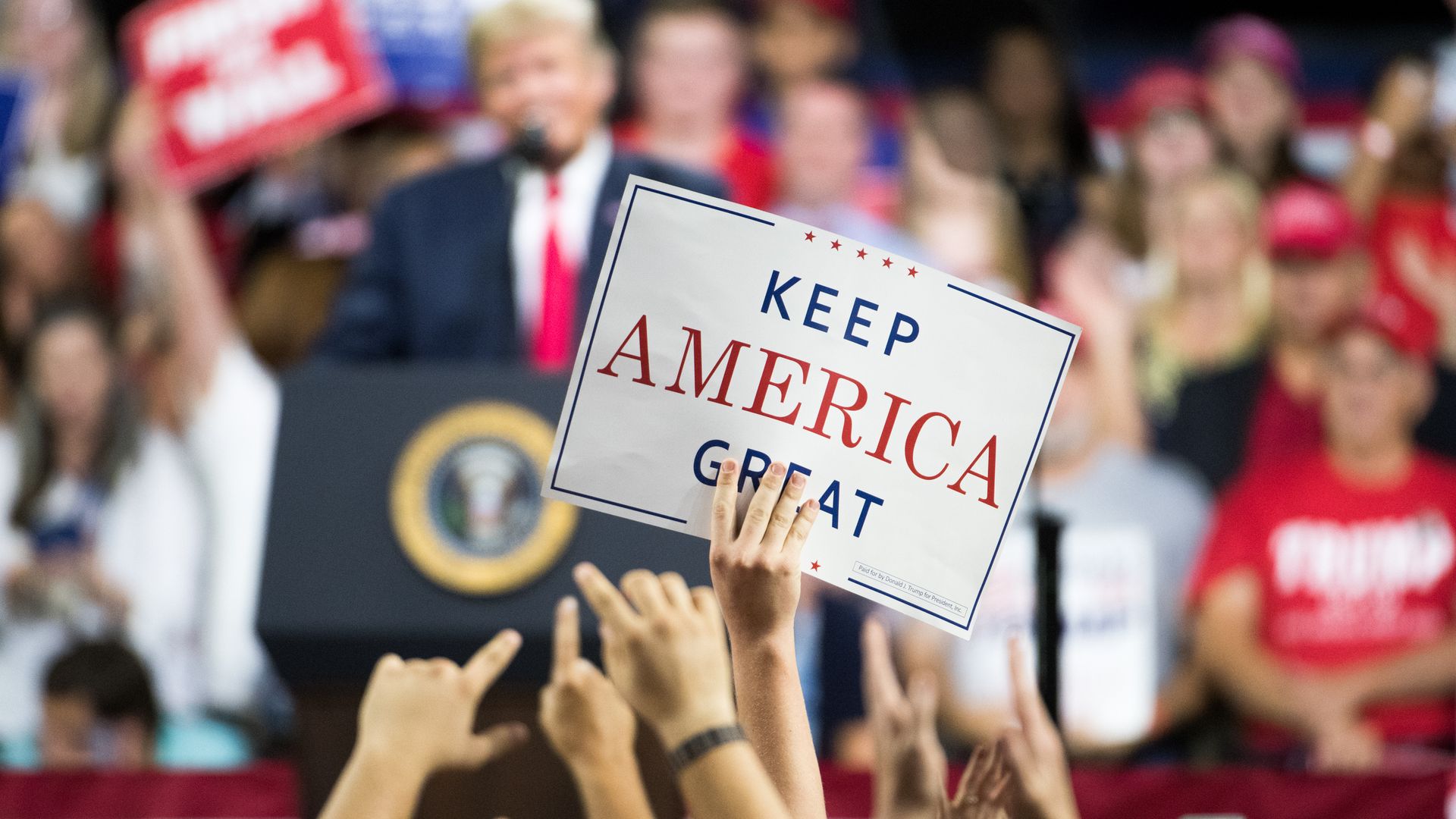 Supporters at a Trump rally hold up a "Keep America Great" sign